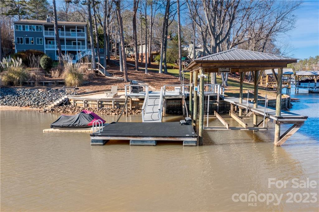 The lake life is calling you! Meticulously maintained WATERFRONT HOME with views of Lake Wylie from almost every room of this 2436 sq ft, 3 bdrm, 2 1/2 bath charmer! Featuring an open floorpan with hardwoods, granite countertops, SS appls, gas range & large eat in kitchen with island. One of the coolest features is the 360 view free standing fireplace that is just waiting for new memories to be made around it!  You will be living out back on the many covered porches that lead you to the beautifully manicured .32 acre lot with private, deep water covered dock, boat lift, impressive seawall and your very own sandy beach to launch your paddle board or kayak. Spend the cool evenings in your hot tub unwinding with unobstructed views on truly one of the best lots in Tega Cay! Storage galore inside and out for all of your lake toys. This home has everything you're looking for and things you didn't even know you wanted! Far too many improvements to list, please see attached list of upgrades.