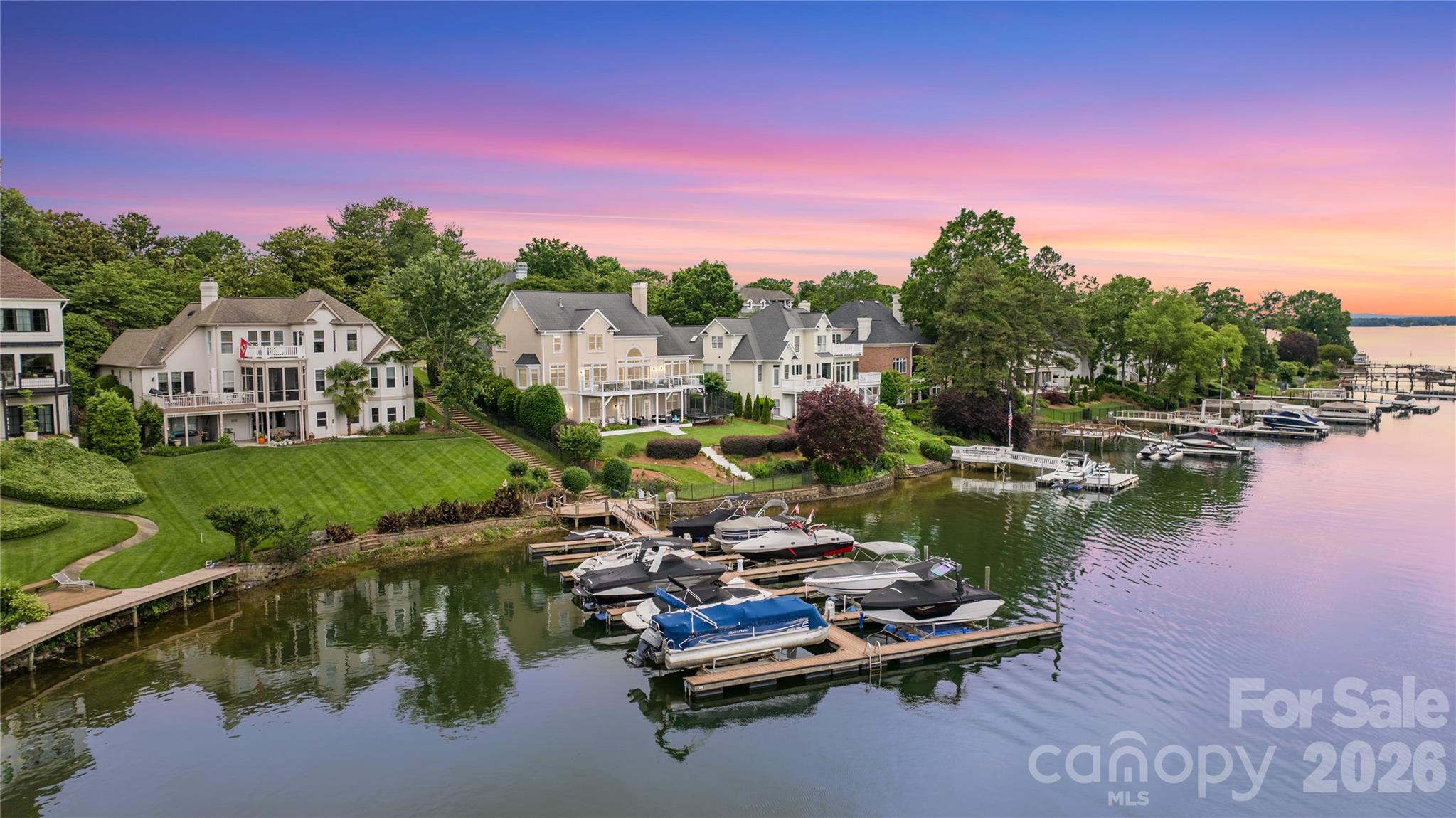 Stunning lakefront home in The Peninsula with wide Lake Norman views and boat slip with lift. Tucked at the end of a quiet cul-de-sac, this beautifully updated residence is designed to maximize seamless indoor-outdoor living with expansive walls of windows framing breathtaking water views throughout the main living areas. The renovated main level features a chef’s kitchen with premium Thermador appliances, open-concept living spaces, and a luxurious primary suite with updated spa-inspired bath and stunning lake views. Step outside to an expansive terrace perfect for entertaining or relaxing lakeside. Upstairs offers two bedrooms plus an optional 6th bedroom/bonus room. The finished walk-out basement includes two additional bedrooms, full bath, and versatile wet-storage room with additional laundry ideal for lake gear and storage. Flat manicured backyard with direct lake access and boat slip just steps away. Room for a pool with preliminary PPOA approval. Golf cart to The Peninsula Golf Club to enjoy golf, tennis, pickleball, fitness center, pool, and clubhouse amenities (membership separate). Rare opportunity to enjoy refined waterfront living in one of Lake Norman’s most desirable communities.