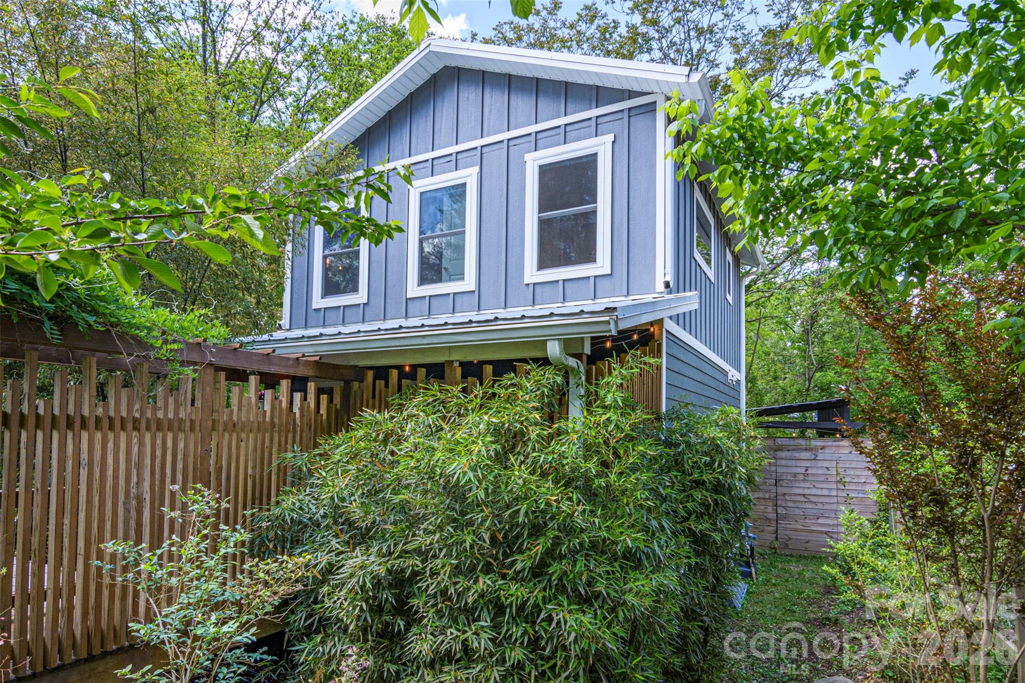Hidden West Asheville Gem with Creek, Private Wraparound Deck and Pergola!
Tucked away in West Asheville, this move-in ready 3-bedroom, 2-bath home offers privacy, charm, and a truly unique setting. Enter through a beautiful wisteria-covered arbor into a warm, light-filled home featuring tall ceilings and natural bamboo flooring throughout. Step into an inviting living space with striking exposed wood beams while the kitchen showcases artistic Spanish tile that adds character to the heart of the home.
French doors lead to a private wraparound deck that extends the living space outdoors. The backyard features a covered pergola perfect for barbecues, surrounded by a lush oasis of greenery, bamboo, and blooming flowers. A small creek runs along the property, and the home sits safely in a no-flood zone.
Energy-efficient Mitsubishi mini-split systems provide heating and cooling, along with a new tankless water heater for endless hot water. All just a short walk to West Asheville’s favorite restaurants, coffee shops, and bars, with downtown Asheville, River Arts District and Biltmore only minutes away!