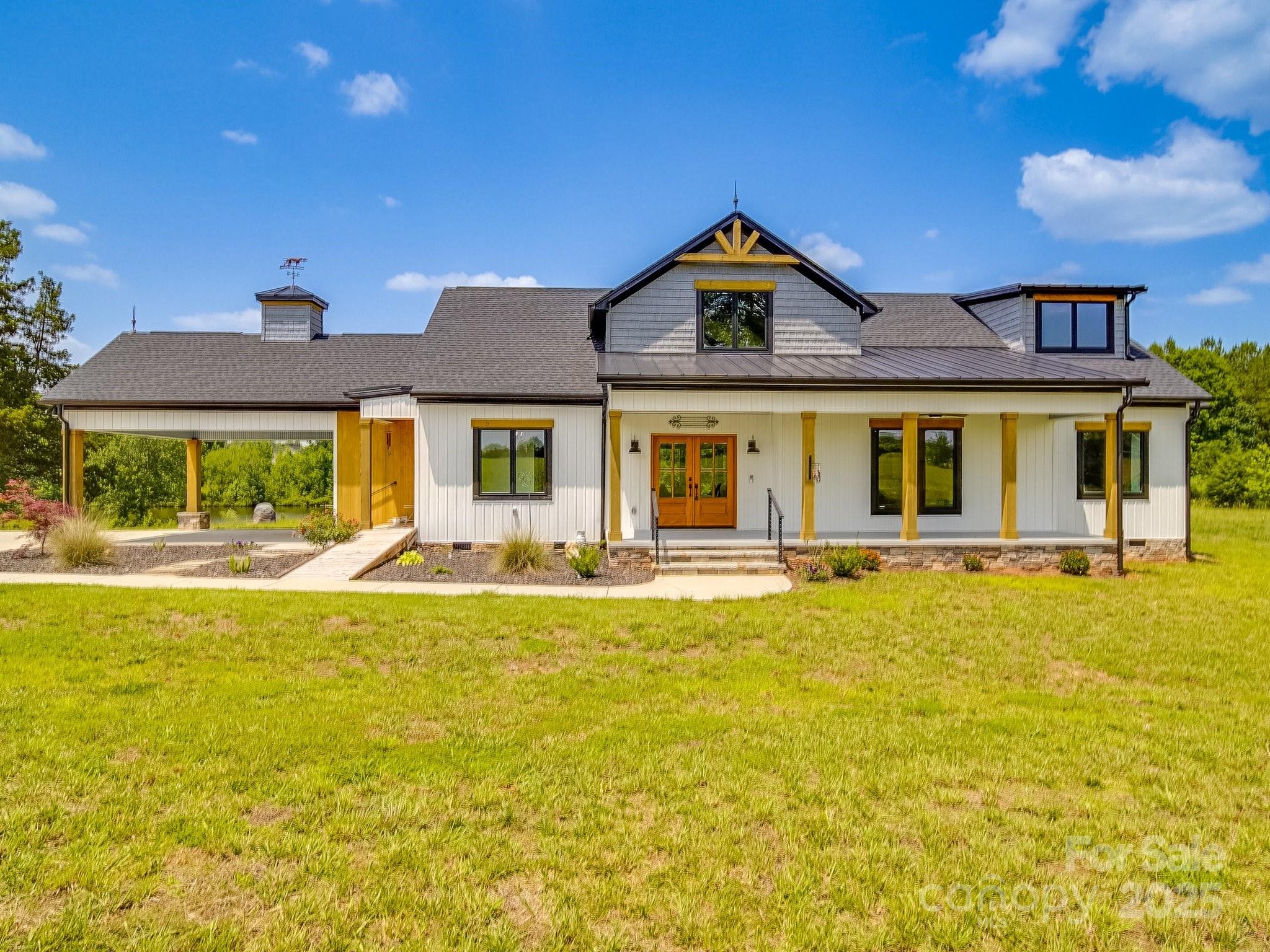 Nestled on over 9 acres of serene countryside, this exquisite modern farmhouse ranch offers the perfect blend of rustic charm & contemporary elegance. A spacious front porch sets the stage for relaxation & Southern hospitality. Step inside to an open split-bedroom floorplan, designed for both comfort & functionality. Natural light pours in through an abundance of windows, highlighting the seamless flow of indoor and outdoor living. The luxury kitchen stuns with an oversized island, perfect for entertaining, while overlooking the 2-story great room with soaring ceilings & cozy fireplace. Cornered barn doors open to a versatile billiards room, easily adaptable into a formal dining space, playroom, or home office. The primary suite offers a large walk-in closet & elegant ensuite with a soaking tub & seamless tile shower. Two additional bedrooms, with walk-in closets. Upstairs, showcases a bright & airy loft Enjoy the best of country living while remaining close to shopping and dining.