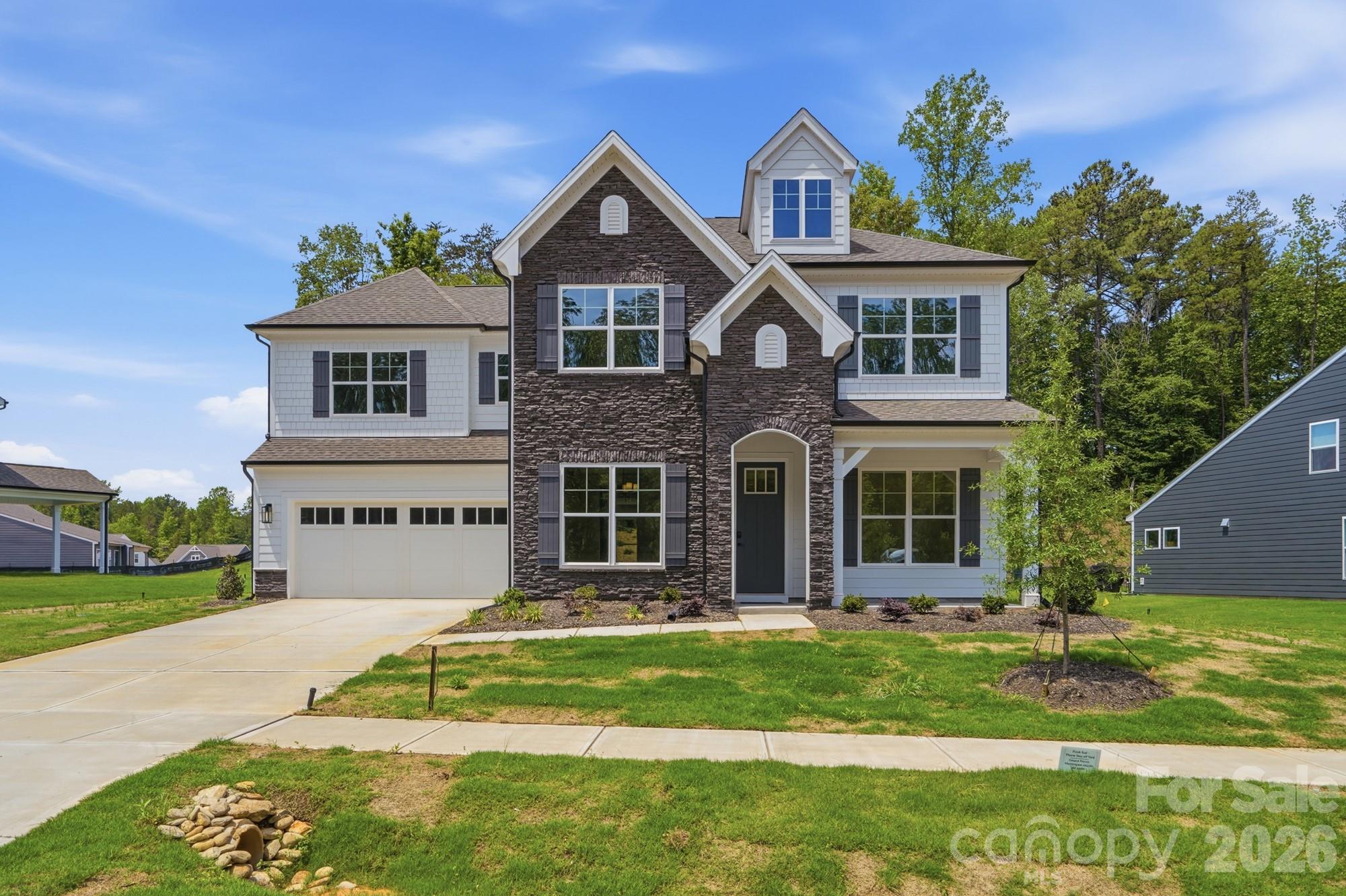 This Colfax plan features a guest suite on the main with an ensuite bath AND a secondary bedroom upstairs, also with an ensuite bath. The home has 5 bedrooms, 4.5 baths, a sunroom and more than 3,600 square feet of living space. The main floor also features a designer kitchen with a butler pantry, family room with Cosmo fireplace and shiplap surround, powder room, dining room with tray ceiling, and an office with French doors and a faux coffered ceiling. The kitchen features white cabinets, quartz counters, a tile backsplash, and stainless appliances, including a gas cooktop, range hood, and wall oven. The upper floor has 9-foot ceilings & includes the loft, primary suite, three secondary bedrooms, two full baths, and the laundry room with storage cabinets. Other extras include quartz counters in all baths, metal balusters, and Enhanced Vinyl Plank flooring. This home has it all and more! Visit today!