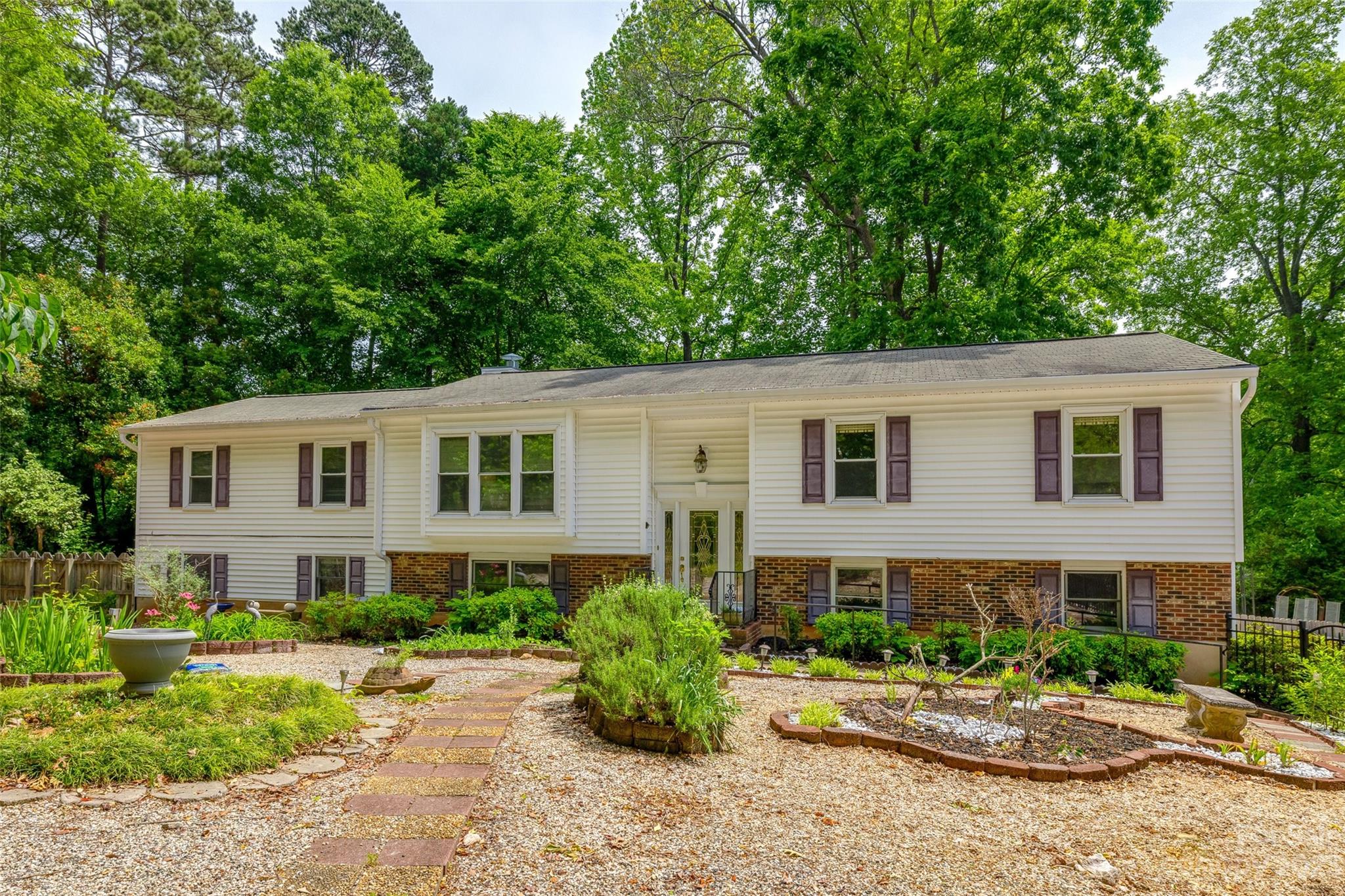 This gem will not last! Custom built home originally lived in by builder is ready for your touch! Main level features 2 large living areas, 4 bedrooms (1 currently used as an oversized office), 2 full baths, kitchen, separate dining area and entrance to covered composite back deck. Lower level features a 2nd kitchen, living area with fireplace, bedroom, full bath with oversized walk-in closet, half bath, and separate workshop space. Gorgeous fully fenced-in yard with several gardens to enjoy the outdoors and tons of usable space! Home has great potential for multi-generational living or larger families. Close to shopping and interstate for ease of commute/travel!