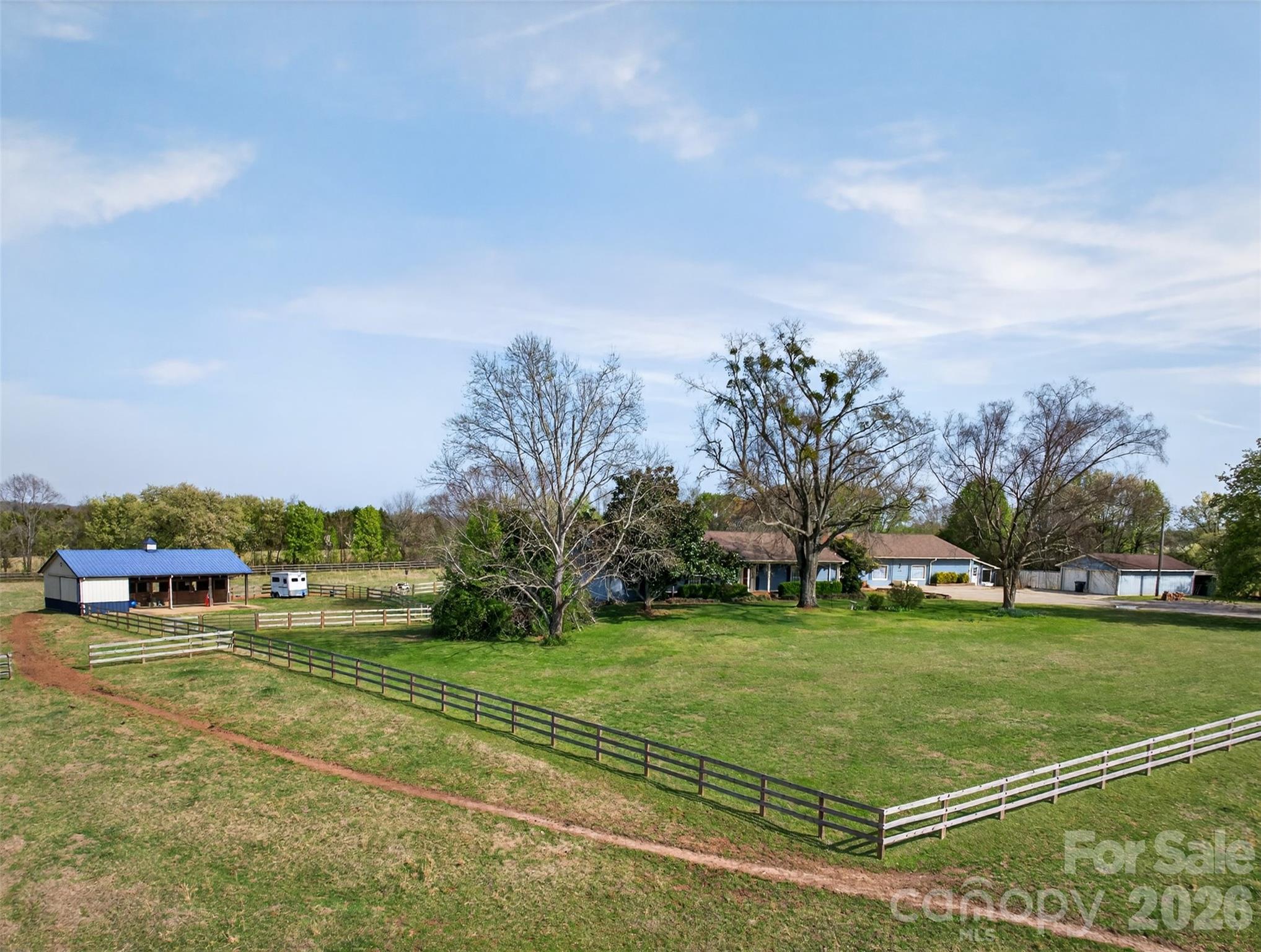 Have you been searching for that unicorn property that works for you, your horses, your dogs, extended family, and even your next big idea?
Well… here it is.
Set on approximately 8 acres in an incredibly convenient location near Tryon, Landrum, and Boiling Springs, this one-of-a-kind property delivers the kind of flexibility that is almost impossible to find. Whether you are dreaming of country living, an equestrian setup, space for multi-generational living, or room to grow a passion project, this property checks every box.

The home has seen several updates and features 2 bedrooms and 2 baths on the main level, with recently refinished Alabama Pine hardwood floors, a striking custom fireplace, and a sunroom overlooking the horses and pasture. With all new windows and a mini split, the sunroom is ready for year-round enjoyment.

The walk-out basement adds even more versatility with 1 bedroom, 1 bath, a full kitchen, and a large entertainment area—perfect for extended family, multi-generational living, guest quarters, or a caretaker’s residence. For added peace of mind, a radon mitigation system was installed in 2023.

Horse lovers will appreciate the thoughtful farm setup, including a 3-stall shed row Morton barn with overhang, tack room, hay storage, thriving pastures, recently replaced 3-board fencing, and cross-fenced pastures for easy rotational grazing.

And then there is the bonus space that truly sets this property apart: an attached climate-controlled building with over 3,100 square feet, previously operated as a successful pet boarding business. The possibilities here are endless—hobby space, workshop, storage, home-based business, or future venture. Out back, you’ll find 30 climate-controlled kennels with exterior access, plus multiple fenced runs for dogs.

This is more than a home. It is a rare chance to own a modern, flexible farm property with room for your lifestyle, your animals, your family, and your future.

THIS PROPERTY IS BY APPOINTMENT ONLY! Please do not drive into the driveway without an appointment to keep dogs in the yard safe!