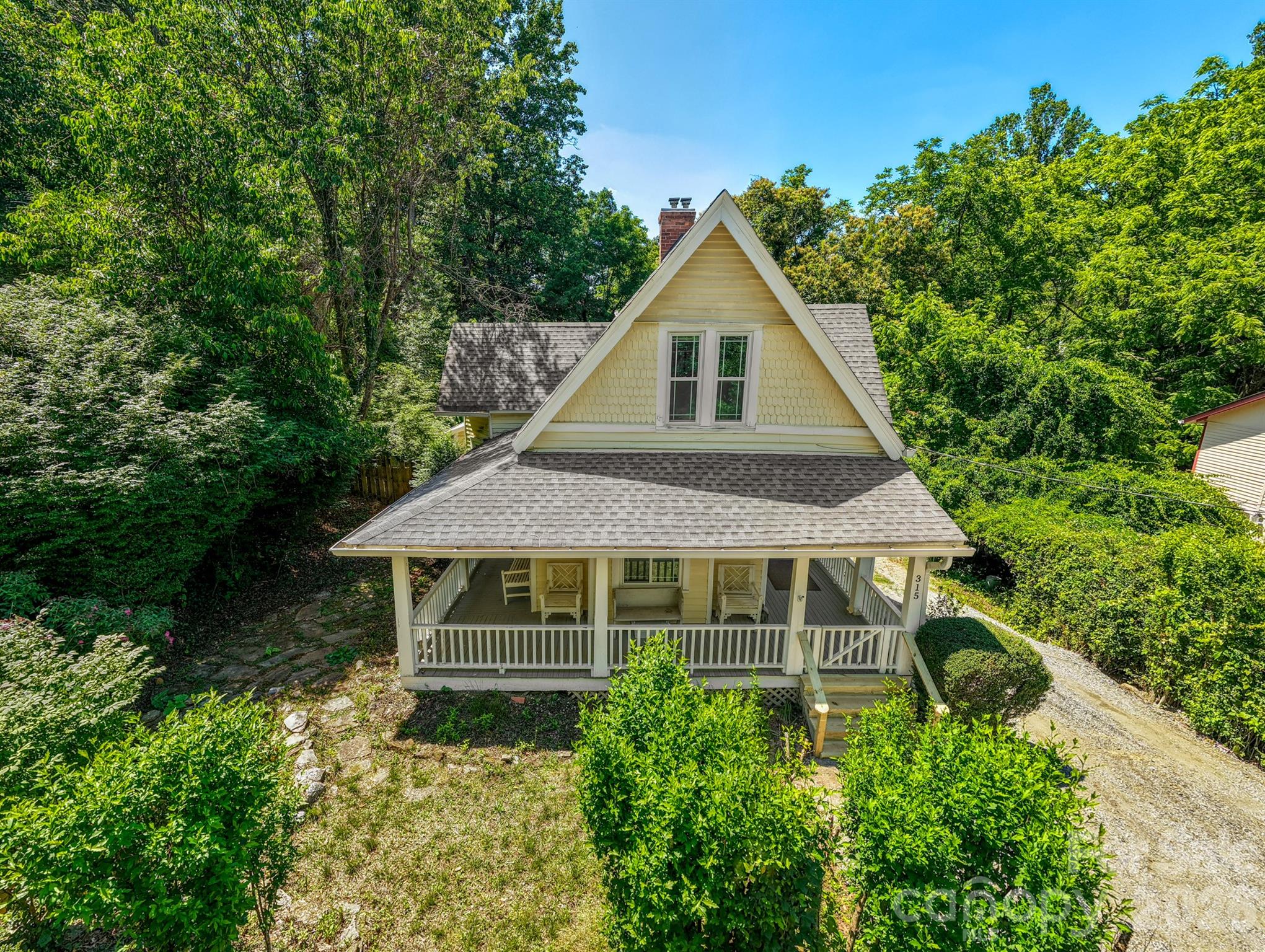 Now offering $5,000 seller credit at close! New parking and a much wider driveway entrance has been added on the main level! Experience the charm of this yellow in-town Victorian cottage only a short walk from Main Street in Saluda. With 4 bedrooms and 2 full baths, this could be a mountain vacation home, STR, or new place to call home. This historic private oasis in the middle of town invites you to relax on the front porch where you can view the pond feature teaming with wildlife. The cottage also boasts plenty of outdoor entertaining space on the covered pack porch, deck, and private fenced in backyard. Historic home enthusiasts will note the scalloped exterior siding feature and accents of exterior Victorian trim. This charming get-away boasts high ceilings, heart pine floors, beadboard paneling, a claw foot tub, antique doors and hardware. All with the modern conveniences of an updated kitchen. Priced to sell! Walkable to award-winning restaurants, museums, boutique shopping, the longest running grocery store in NC, and music and dog festivals.