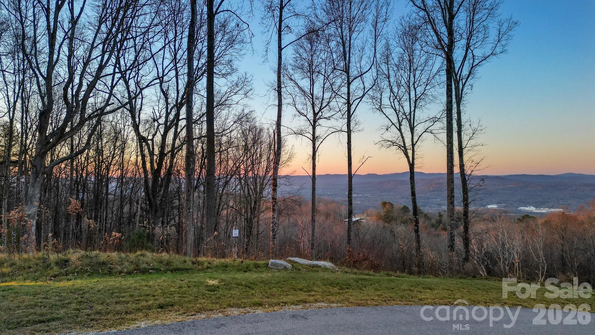 Experience breathtaking mountain views at 198 Mossy Rock Way! This homesite features expansive vistas, including stunning sunrises to the east and picturesque views to the west. The gently sloped topography provides easy access to miles of hiking trails that wind throughout the community. Nestled in the iconic Couch Mountain community, which spans 395 acres of low-density living, residents can step right outside their doors to connect with nature. Enjoy 4 miles of hiking trails within the 138-acre nature preserve, a greenhouse, community gardens, beehives, and more. Conveniently located between Asheville and Hendersonville, this area offers easy access to both charming mountain towns.