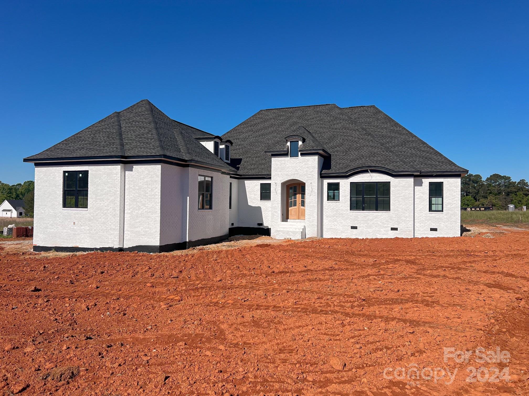 Introducing a masterpiece of modern living in lovely Edmunds Farm! Home is in final construction stage and will be completed in 30 days! This stunning white brick home boasts 10-foot ceilings, 8-foot doors, and meticulous attention to detail. Walking in the front door you are immediately greeted by craftsmanship. Spacious kitchen with Quartz counters, brick backsplash, an abundance of cabinets with a huge center island. Open floor plan with brick accent wall above fireplace.  Enjoy the tray ceilings in the primary suite, complete with a luxurious walk-in shower and oversized walk-in closet. Coffered ceilings in main living area with elegant wainscotting throughout the home. Work from home in the private study. Step out back and sip your morning coffee on the covered back porch. This home is a must see to take in all of the details! Situated on a corner lot, this home is a sanctuary of style and comfort.
