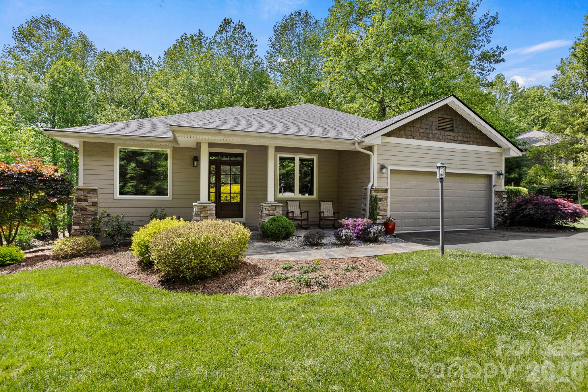 Exceptional home in highly desirable Kenmure, a gated golf course community offering upscale amenities and an outstanding mountain lifestyle. Situated on almost an acre of beautifully landscaped grounds with the utmost privacy, this stunning home is surrounded by a peaceful natural setting and features level entry and driveway access for easy living. The main level showcases an inviting open floor plan with upscale finishes and exceptional attention to detail throughout, including hardwood floors and custom blinds. The dramatic great room features vaulted ceilings, a magnificent floor-to-ceiling stone gas fireplace with hearth and a wall of windows and sliders that open to the deck while framing gorgeous views of the private natural surroundings. The great room flows seamlessly into the dining room and spacious kitchen, creating the perfect atmosphere for entertaining and family gatherings. The chef’s kitchen is beautifully appointed with granite countertops, tile backsplash, abundant cabinetry, wine refrigerator, high-end stainless steel appliances and a charming breakfast nook area. The elegant dining room is highlighted by two large picture windows that perfectly capture the beauty of the outdoor setting. The luxurious primary suite offers a designer walk-in closet plus an additional closet, a spa-inspired bath with tile walk-in shower and glass door, double vanity, soaking tub, and private water closet. A private door from the primary suite leads directly to the inviting screened porch, creating a peaceful retreat to enjoy the tranquil surroundings. Completing the main level is a study with designer walk-in closet, powder bath and a spacious mudroom/laundry room with built-in cabinetry/pantry, shelving and washer/dryer hookup. The lower level provides exceptional additional living space featuring a spacious family room with wet bar and cabinetry, two guest bedrooms and a full bath with walk-in shower and granite vanity. There is also a second laundry room with utility sink and generous storage areas. Outdoor living is truly exceptional with multiple spaces designed to enjoy the beauty and privacy of this remarkable property, including the covered front porch, gorgeous screened porch, upper-level deck and lower-level deck with direct backyard access making it especially pet friendly. Additional highlights include a newer roof installed in 2022, Eco water and filtration system and lawn maintenance provided by the HOA for low-maintenance living. Located in one of Kenmure’s most desirable areas, this stunning home offers luxury, comfort, privacy and exceptional craftsmanship in an unforgettable setting.