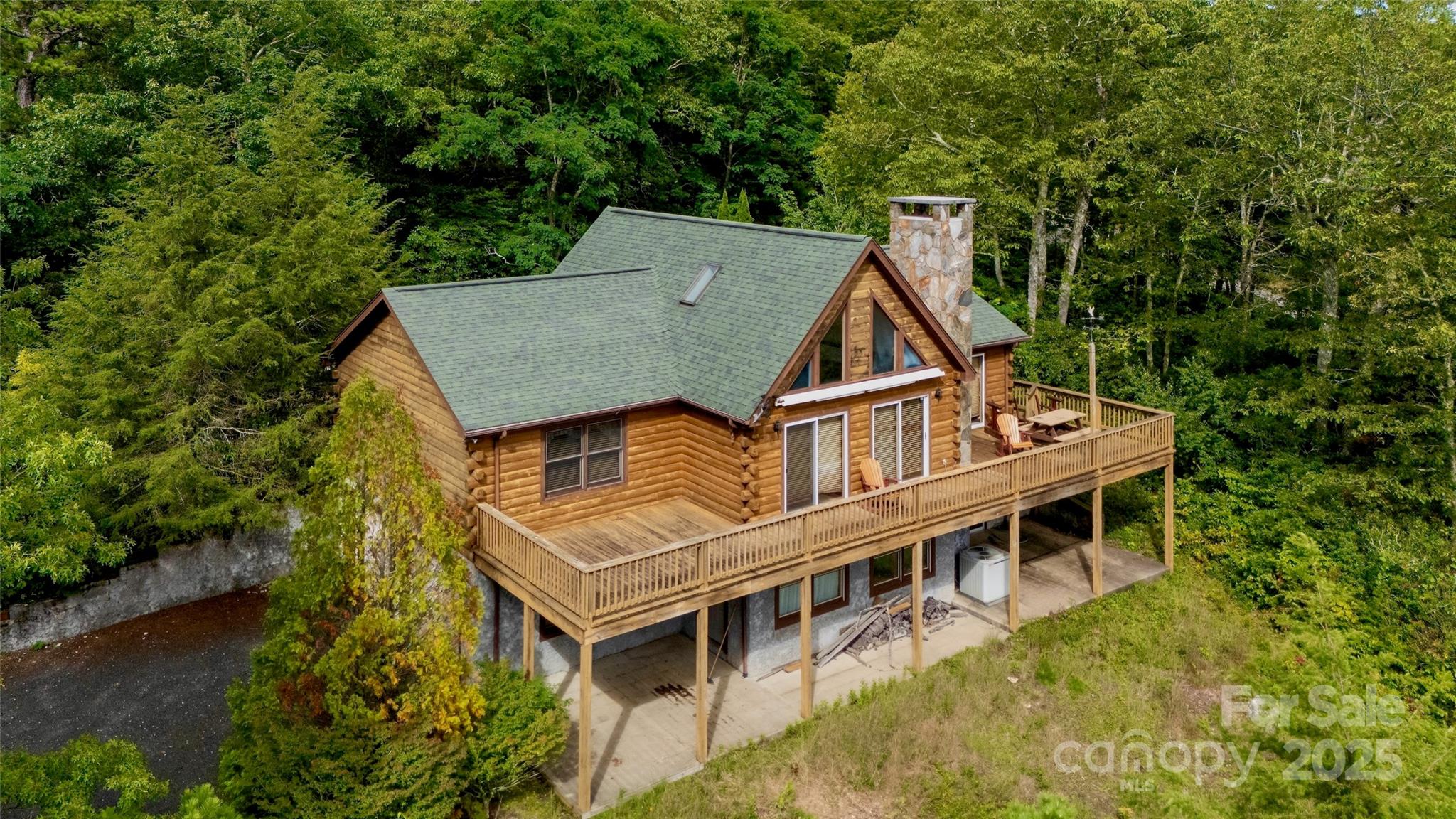 Unparalleled Mountain Retreat with Stunning Mt. Mitchell Views
Introducing a rare opportunity to own this exceptional Blue Ridge Log Home® in the prestigious Alpine Mountain Community of Greater Little Switzerland. Debuting on the market for the first time, this meticulously crafted log cabin offers mesmerizing, protected southern views of Mt. Mitchell and the surrounding Blue Ridge Mountain peaks, set on a pristine +/- 3.79-acre lot with park-like landscaping and a wide, nearly level driveway accented by Keystone® block elements, partially wrapping to the basement garage.
Built by America’s innovative leader in modular log homes, Blue Ridge Log Cabins—recognized by Inc. magazine in 2008 and 2009 and featured on HGTV’s “Amazing Log Homes” and ABC’s “Extreme Makeover: Home Edition”—this 1,712-square-foot, three-bedroom, two-bath residence with a full basement combines rustic elegance with modern efficiency. Hand-stacked in a state-of-the-art 110,000-square-foot South Carolina facility, the home exceeds state codes and boasts 20-30% greater energy efficiency than traditional builds, thanks to its solid log construction and controlled factory process.
The open-concept main level features a living room with vaulted ceilings, exposed wooden beams, two skylights, and expansive A-frame windows framing the mountain vistas. A high-end Buck Stove® fireplace insert with blower, sourced locally from Spruce Pine, NC, anchors the space, complemented by a built-in board game closet. The adjoining dining area offers a solid wood oval table seating six, while the country-style kitchen showcases light maple cabinets with raised-panel doors, white ceramic knobs, durable mauve laminate countertops, and white appliances. Newly refinished hardwood floors, thematic rugs, and a balanced mix of wood and drywall enhance the inviting ambiance.
The master bedroom ensuite is a serene haven with warm wooden walls, a sturdy bed with a leaf-patterned comforter, a leather recliner, and a ceiling fan. It includes an attached bathroom and a spacious walk-in closet with open shelving, all bathed in natural light from windows overlooking Mt. Mitchell. Upstairs, a versatile loft with skylights, a beige sofa, and a leather recliner offers stunning views and potential as a second living area, office, or play space. Two cozy guest bedrooms feature double beds, wooden furnishings, and mountain views, ideal for visitors.
The basement houses a two-car garage with a concrete floor, wooden workbench, built-in shelving, and large windows, plus an unfinished area with walk-out access to a concrete patio—perfect for future expansion. A Trane® HVAC system, electric hot-water heater, and main-level laundry closet ensure modern comfort.
Nestled in the well-maintained Alpine Mountain Community, with access to trails and Long Branch Falls, this home offers mild deed protections to preserve value. Conveniently located 5 minutes from Little Switzerland, 10 minutes from Spruce Pine and Blue Ridge Regional Hospital, and near the Blue Ridge Parkway, it’s also 20 minutes to Burnsville, 30 minutes to Marion and Lake James, 50 minutes to Asheville or Boone, and 2 hours from Charlotte.
Perfect as a weekend getaway or forever home, this log cabin blends quality craftsmanship, breathtaking views, and prime location. Schedule your private tour today!