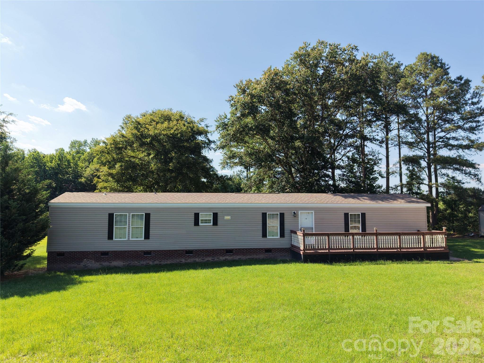 Move-in ready 2014 Fleetwood home on 1.97 acres in the country, set back from the road for privacy. This 3-bedroom, 2-bath home features a spacious primary suite with walk-in closet, double vanity, garden tub, and shower. The open kitchen and living area create a welcoming space, while two additional bedrooms and a full bath complete the split floor plan. Enjoy central air, electric heat, Whirlpool appliances, brick underpinning, and optional upgraded exterior insulation. Large decks front and back provide outdoor living, and a carport for four cars plus a storage building offer plenty of space for vehicles and tools.