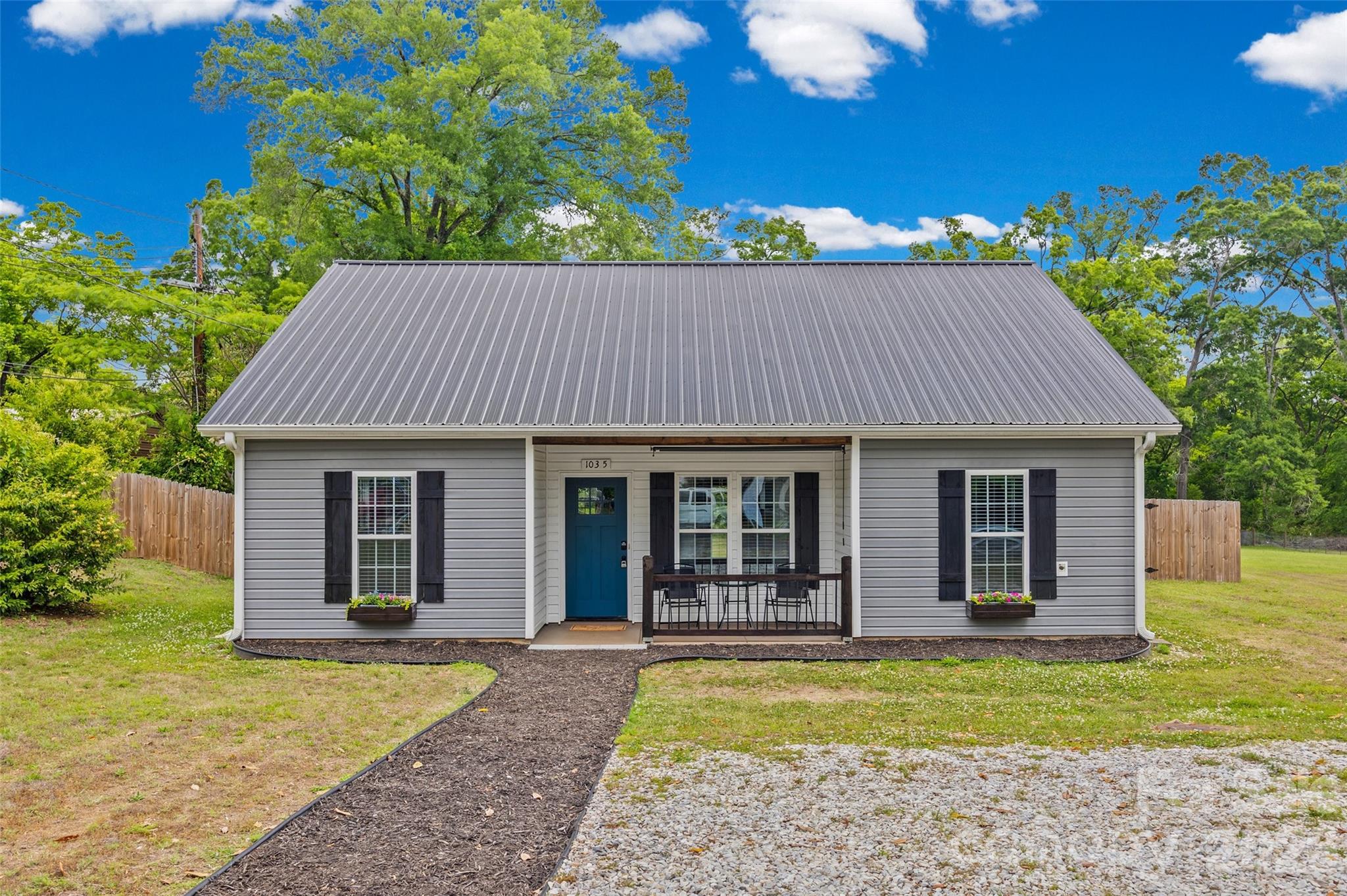 Tucked into a charming area of downtown Chester, this beautifully crafted 2021 home blends modern convenience with timeless character. Situated on a large lot, this 3-bedroom, 2-bath home offers an inviting open-concept layout with stylish LVP flooring throughout for easy maintenance and everyday durability. The floor plan lives large and the spacious kitchen, living, and dining areas flow seamlessly together featuring granite countertops, custom touches, and warm finishes that make the home feel both functional and welcoming.  You'll especially love the laundry room with pantry storage off the kitchen. Character shines throughout with detailed ceilings, shiplap accents, and beautiful wood details that add charm and personality to every space. The primary suite offers a huge walk-in closet, while all bedrooms provide generous storage and comfort. Outside, enjoy peaceful mornings on the covered front porch or unwind on the covered back patio overlooking the expansive fenced backyard.  This home was designed for easy living without sacrificing style. A rare opportunity to own newer construction with charm, space, and curb appeal in the heart of Chester.