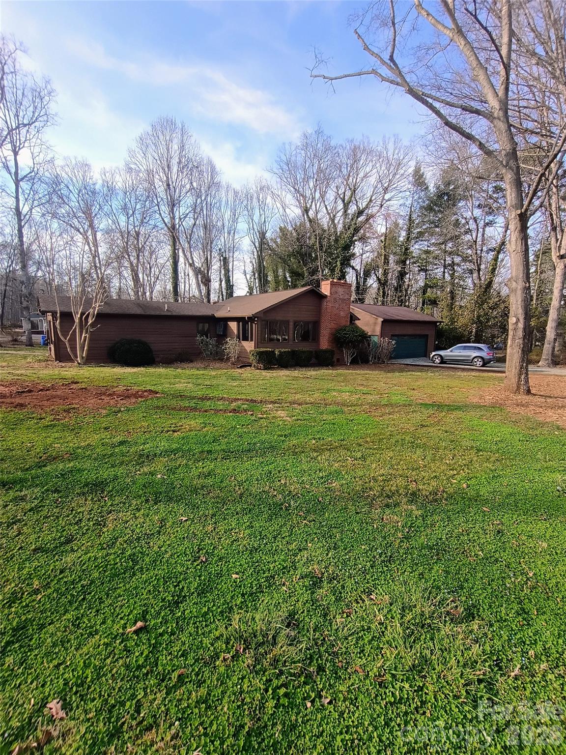 Excellent location, not in Town limits, but has public water and sewer.  The soaring ceiling in the open concept  living and kitchen is a great place for family gatherings and entertaining around the fireplace.  Also, a large den for the overflow guests.  A attached 2 car garage, with space for a workshop and a outside storage building for all your hobbies and projects.  Some fresh interior paint and some new carpet. The original home was a 1980 manufactured home.   The screened in back porch makes a wonderful place for relaxing.