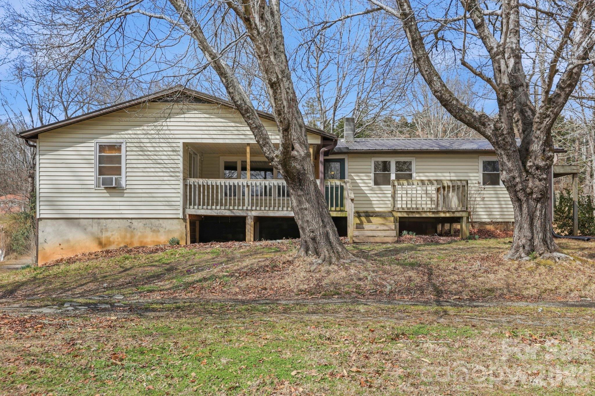 Don't miss this his 5 bed, 4 bath Pisgah Forest home that offers a tremendous opportunity to renovate and gain equity! Priced to allow room for upgrades and TLC, the home is being sold 'as is'.  Boasting more than 2000 sq ft of incredibly versatile and open square footage, the main level has two ensuite bed/bath combinations plus two additonal bedrooms and another full bath.  Ample common living areas, a convenient central kitchen, and a large laundry room complete the main level.  Large front and back decks (both need work) bring the outdoors in on this large, peaceful lot.  Interior stairs lead to a garage and daylight basement with its own exterior entrance and partially finished space. The convenient location is perfect for lifestyle and recreation, only minutes from both downtown Brevard and Pisgah NF. With opportunities to create a delightful residential home for your family, multi-generational accommodations, or or possibly separate rental units, this property will reward the buyer with vision.