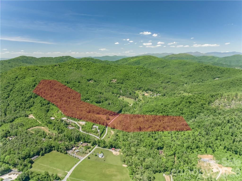 RARE BUILDER/INVESTOR OPPORTUNITY! 53+/- breathtaking acres of rolling pasture and mature hardwoods in prime South Asheville. A developer's dream or ultimate private estate, featuring pristine Merrill’s Cove Creek winding through the property. Existing brick ranch sold AS-IS/WHERE-IS, perfect for a custom renovation or temporary residence while you build. Enjoy unmatched mountain tranquility and total privacy, located just 7 minutes from Hendersonville Road's premier shopping, dining, and amenities. Unlimited potential for a luxury homestead, family compound, or private retreat. Opportunities of this scale and location rarely hit the market. Schedule your private tour today!