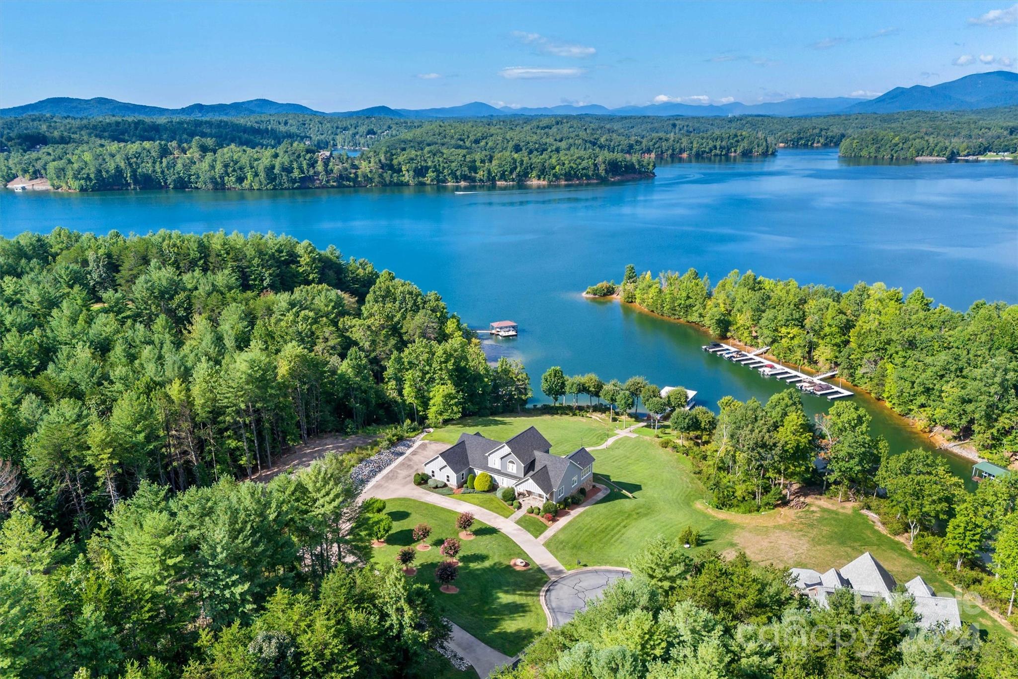 This extraordinary 1.95-acre waterfront property on Lake James combines luxury and nature with breathtaking mountain views. The home, in pristine condition, features custom wrought iron work throughout, including intricate railings, a custom grill, and decorative lamp posts, adding elegance and uniqueness to every corner. Enjoy seamless lake access with a 2-bay dock, perfect for water activities. The home is designed for convenience and entertainment, boasting a 3-bay garage, an additional full kitchen in the basement, and spacious living areas. This property comes fully furnished and includes a pontoon boat, jet ski, golf cart, and more, making it an unparalleled turn-key retreat. Whether you're relaxing by the water, entertaining guests, or exploring the outdoors, this property offers it all. Don’t miss the chance to own this luxurious and fully-equipped lakeside haven, perfect for those seeking both tranquility and adventure.