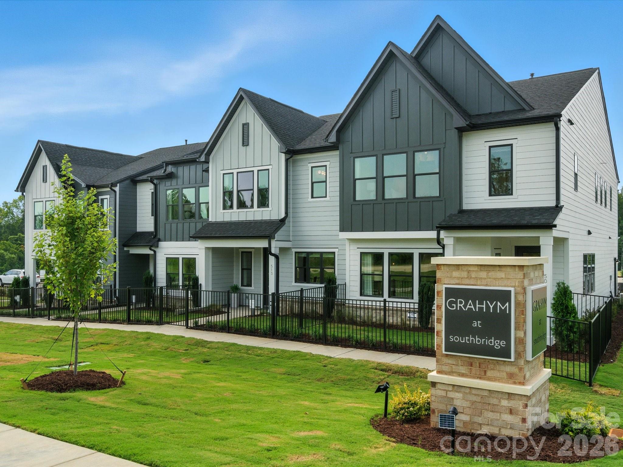 Welcome to our stunning Clarion model home available for sale in Grahym at Southbridge, one of Fort Mill, SC's most sought-after new townhome communities, just minutes from the North Carolina border and the Charlotte metro. The Clarion plan delivers the open-concept living, beginning with a sun-drenched main floor where the kitchen takes center stage: white cabinets, white quartz countertops, a large single-bowl stainless steel sink with a Delta Essa Touch faucet, striking framed polished chevron backsplash tile, black hardware, and a spacious walk-in pantry, all opening seamlessly to the living area. A fenced front yard maintained by the HOA and a covered front entry add rare outdoor charm, while a drop zone at the garage entrance keeps daily life organized. Oak box stairs with sleek black metal baluster open rails lead to a light-filled second floor featuring a versatile loft. The serene primary suite features a tiled walk-in shower, a generous walk-in closet, and a dual-vanity bath finished in white quartz and white cabinetry. Enjoy neighborhood walking trails, maintained landscaping, top-rated Fort Mill schools, and easy access to shopping, dining, and major commuter routes, all in a neighborhood designed around connection and convenience. As a professionally decorated model home, this residence is also available with a designer-curated furniture package, inquire today for details on purchasing the home fully furnished.