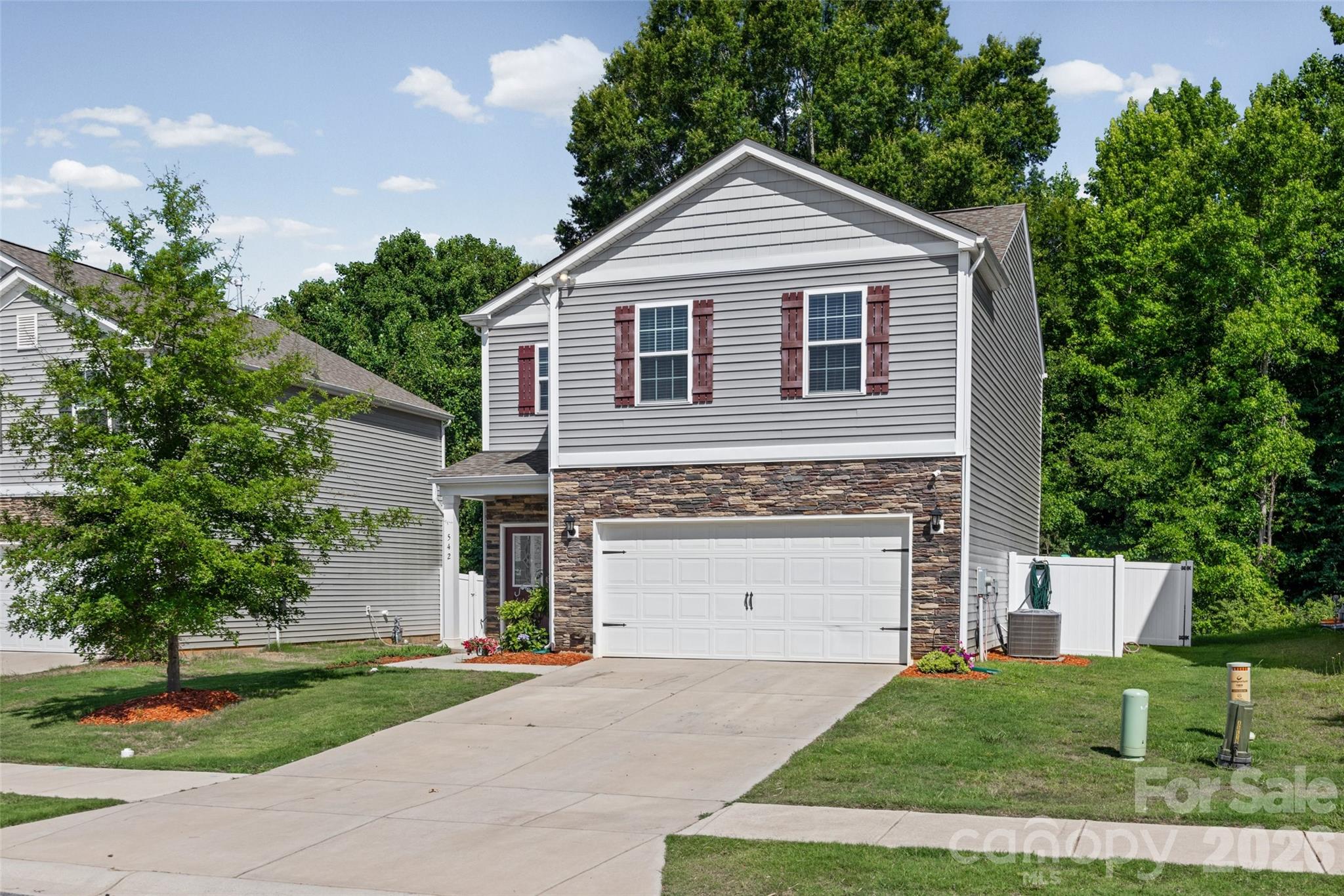 This nearly-new two-story home checks every box. Curb appeal starts with a stone water-table accent and crisp burgundy shutters, leading into an open concept living space - offering 9-foot ceilings, gas-log fireplace and Mohawk RevWood flooring throughout the entire main level. The spacious eat-in kitchen features granite countertops, a stylish tile backsplash, stainless steel appliances, over-sized pantry and a gas range!

Upstairs, you'll find 4 generously sized bedrooms, including a spacious primary suite with a large walk-in closet and dual vanity bath. 
This home is also packed with smart-home features, including a programmable thermostat, Z-Wave door locks and wireless switches, touchscreen control panel, home automation platform, video doorbell, and Amazon smart-home devices, providing modern convenience at your fingertips.
Enjoy outdoor living in the private fenced backyard, complete with a rear concrete patio and wooded backdrop that offers added privacy.

Who is ready to move?! Get in touch with us today!