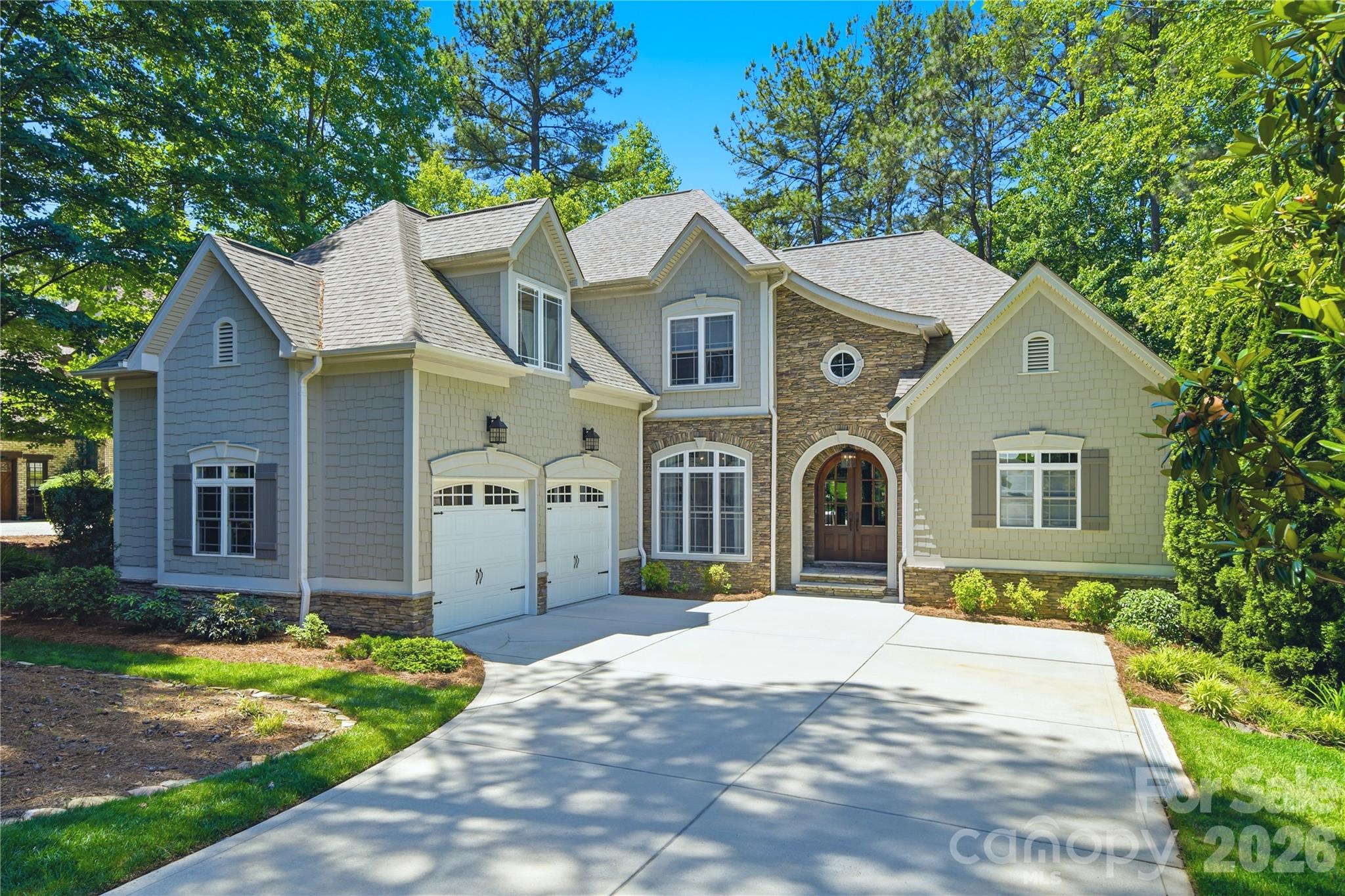 Experience breathtaking waterfront living in this beautifully crafted 4-bedroom, 4½-bath custom home with 4043
sq ft of thoughtfully designed space overlooking stunning Lake Norman. Professionally landscaped and treed yard with seasonal flowering trees and plants. Built in 2006 by John Williams Custom Homes, this exceptional residence combines timeless craftsmanship with lake views from every level. From the moment you enter, the soaring 20-foot vaulted living room ceiling and dramatic floor-to-ceiling custom stone fireplace create an unforgettable first impression. Expansive windows frame lake views from the living room, kitchen, dining area, master suite, upstairs bedroom, downstairs bedroom, family room, exercise room, and lower patio. The living room, dining room, and kitchen offer generous entertaining space for family and friends. The kitchen features a dining area, barstool seating and counter, premium KitchenAid appliances, and custom-built wood cabinetry. Built-in entertainment cabinetry and multiple indoor and outdoor gathering spaces make this home ideal for both relaxed lake life and entertaining guests. The luxurious primary suite offers direct access to the large Trex balcony overlooking the lake, creating the perfect relaxing retreat. The spa-inspired primary bath includes a Jacuzzi tub, oversized shower with dual water jets, handheld spray, and soothing hot water from the Rinnai tankless water heater. The upper floor includes a second bedroom with a private ensuite bath for exceptional comfort and privacy, a third bedroom, a large bonus room, and attic storage. The walkout lower level includes a spacious family room with surround-sound speakers, and a kitchenette, an exercise area, a fourth bedroom with an ensuite bath, extensive storage, and a workshop with a built-in workbench and double exterior doors. A second natural gas stone fireplace and an outdoor wood-burning fireplace create warm, inviting spaces year-round. Outdoor enthusiasts will appreciate approximately 110 feet of shoreline on Lake Norman, with a private boat tie-up and direct kayak/paddleboard launch access. Additional amenities include gated and locked boat storage just one block away and convenient access to the Little Creek Boat Ramp, only 0.6 miles from the home. Roof replaced in 2022.