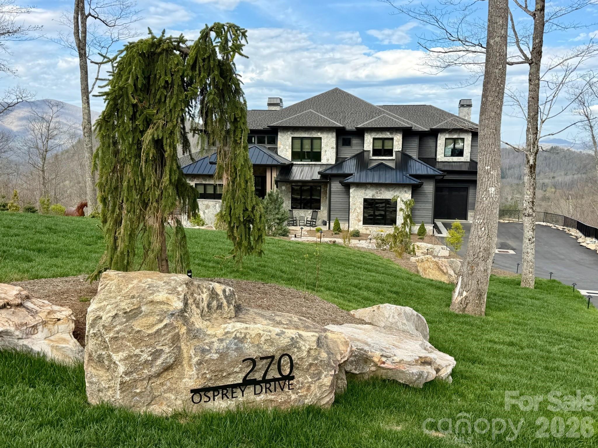 Welcome to Iron Horse Lodge, a newly constructed custom masterpiece ideally positioned within The Lodges at Eagles Nest, just minutes from downtown Banner Elk and moments from the Great Camp Amphitheater and Epic Chophouse. Thoughtfully designed to capture long-range sunset views over the Blue Ridge Mountains, this exceptional home offers a seamless blend of modern mountain architecture, enduring materials, and refined luxury living.

A striking exterior of natural stone, horizontal wood siding, and architectural shingles is accented by standing seam metal roofing and timber columns, creating a warm yet sophisticated presence. Built for longevity, Edge Vesta steel siding is incorporated in hard-to-reach areas for enhanced durability and low maintenance. A custom-engineered foundation with steel beam construction allows for a dramatic cantilevered design—maximizing both structural integrity and panoramic views.

Designed as a true primary residence, every detail reflects a no-compromise approach to craftsmanship. The easily accessible driveway offers ample guest parking, complemented by an oversized two-car garage and additional single-car garage. A well-appointed mudroom with built-in laundry, drop zone, and custom dog wash enhances everyday functionality.

Inside, oversized glass barn-style doors open to a welcoming foyer, anchored by a wine and cocktail lounge—setting the tone for elevated entertaining. A private office with custom architectural doors leads into an expansive living and dining area, where fully retractable glass doors create a seamless indoor-outdoor experience. Step onto over 2,400 square feet of outdoor decks, thoughtfully designed to take full advantage of the home’s breathtaking sunset views.

The chef’s kitchen is outfitted with Thermador Professional Series appliances, dual dishwashers, a wet bar/coffee station with sink and refrigerated drawers, and a fully equipped butler’s pantry with built-in desk, prep space, and abundant storage.

The main-level primary suite offers a private retreat with fireplace, coffee bar, beverage fridge, and sink. Expansive windows frame mountain views, while direct deck access leads to a Bullfrog 6+ person hot tub. The spa-inspired bath features a soaking tub, dual-head shower, and double vanities, complemented by a walk-in closet with its own washer and dryer.

Upstairs, a second en suite bedroom is joined by an additional bedroom with nursery, hidden door access, and a spacious walk-in closet. A large shared bath includes a soaking tub and dual-head shower, while a covered deck captures elevated mountain vistas.

The lower level is where this home truly expands its potential. In addition to a spacious family room, bunkroom suite, full bath, gym, half bath, and wellness room with cold plunge and infrared sauna, the home includes over 1,000+ square feet of additional heated living space currently being completed. Buyers have a rare opportunity to personalize several basement-level spaces—including a theater room and flexible living areas—allowing for customization to suit their lifestyle.

Offered fully furnished with select exclusions, Iron Horse Lodge is a rare opportunity to own a professionally designed, luxury mountain retreat—enhanced by expanded living space, customization potential, and exceptional outdoor living—without the wait of new construction. Interior design by Lucy and Company delivers a bold, curated aesthetic recognized in luxury publications.
