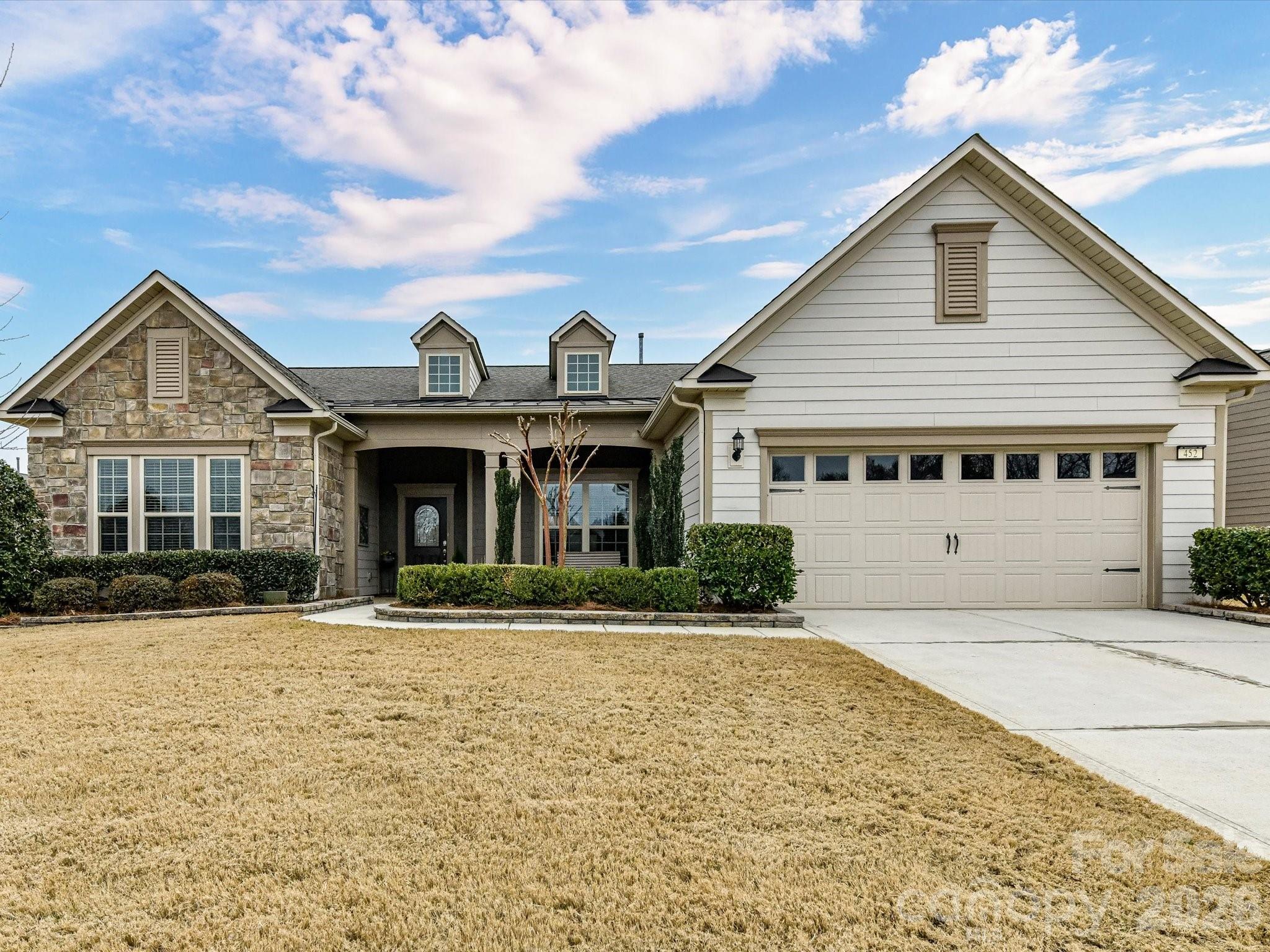 Welcome to this stunning home featuring the Dunwoody Way floor plan, located in the desirable Village M within the Del Webb Carolina Orchards 55+ community. This spacious 3-bedroom home overlooks the community pond and features an open-concept layout with a seamless flow between the dining, kitchen and living spaces. The upgraded kitchen features an extended island with counter seating, KitchenAid Gourmet appliances including a built in microwave and wall oven, soft close cabinets and drawers, granite countertops, tile backsplash, direct hood vent to outside, under cabinet lighting & pantry. Living room with a gorgeous stone fireplace & cedar mantle. Office with French doors & recessed lighting. Primary bedroom complete with a tray ceiling & luxurious bathroom with a large, tiled walk-in shower, dual sinks & custom walk-in closet. Bedroom 3 with an en-suite bathroom. Laundry room with sink and drop zone. Enjoy the spacious stamped concrete screened porch with remoted controlled automatic shades and patio. Upgraded floored attic space over garage for storage. Tankless water heater, whole house air purification & water filtration systems. Epoxy garage floor. Smart home ready with HVAC Nest thermostat & Schlage smart lock. No detail has been spared in this immaculate & tastefully decorated home. This community offers resort-style amenities such as a fitness center, dog park, clubhouses, maintenance-free lawns, indoor & outdoor pools & pickleball courts. Anne Springs Close Greenway entrance across from the community. Experience the best of active adult living in a vibrant neighborhood.