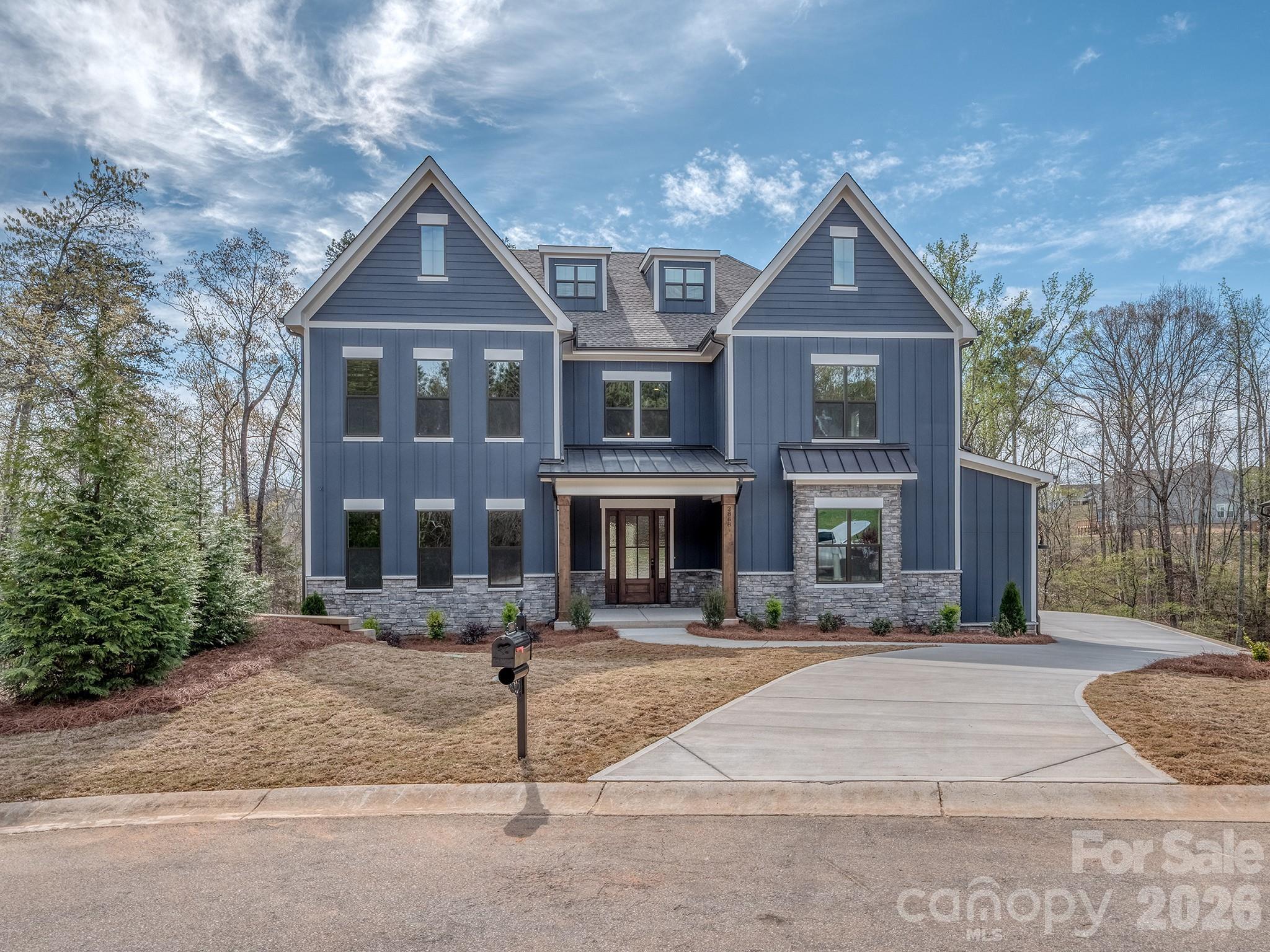 This gorgeous new home is situated on 0.6 acres at the end of a Lake Wylie cove perfect for launching a kayak. The home features 5 bedrooms, 4.5 baths, a spectacular open kitchen, upgraded cabinets and counter tops, large pantry with bar area, heavy trim, a large playroom with media room connected through barn doors, mud room with drop zone, and a covered deck to take in views of beautiful hardwoods and a creek behind the home.  Handsmill on Lake Wylie is one of Lake Wylie's premier gated communities, featuring a quiet atmosphere, a community pool, clubhouse, fitness & recreation areas, walking trails, boat storage & slips for lease. Also, just minutes from top rated Clover schools, restaurants, and shopping. The home will be complete in March of 2026.