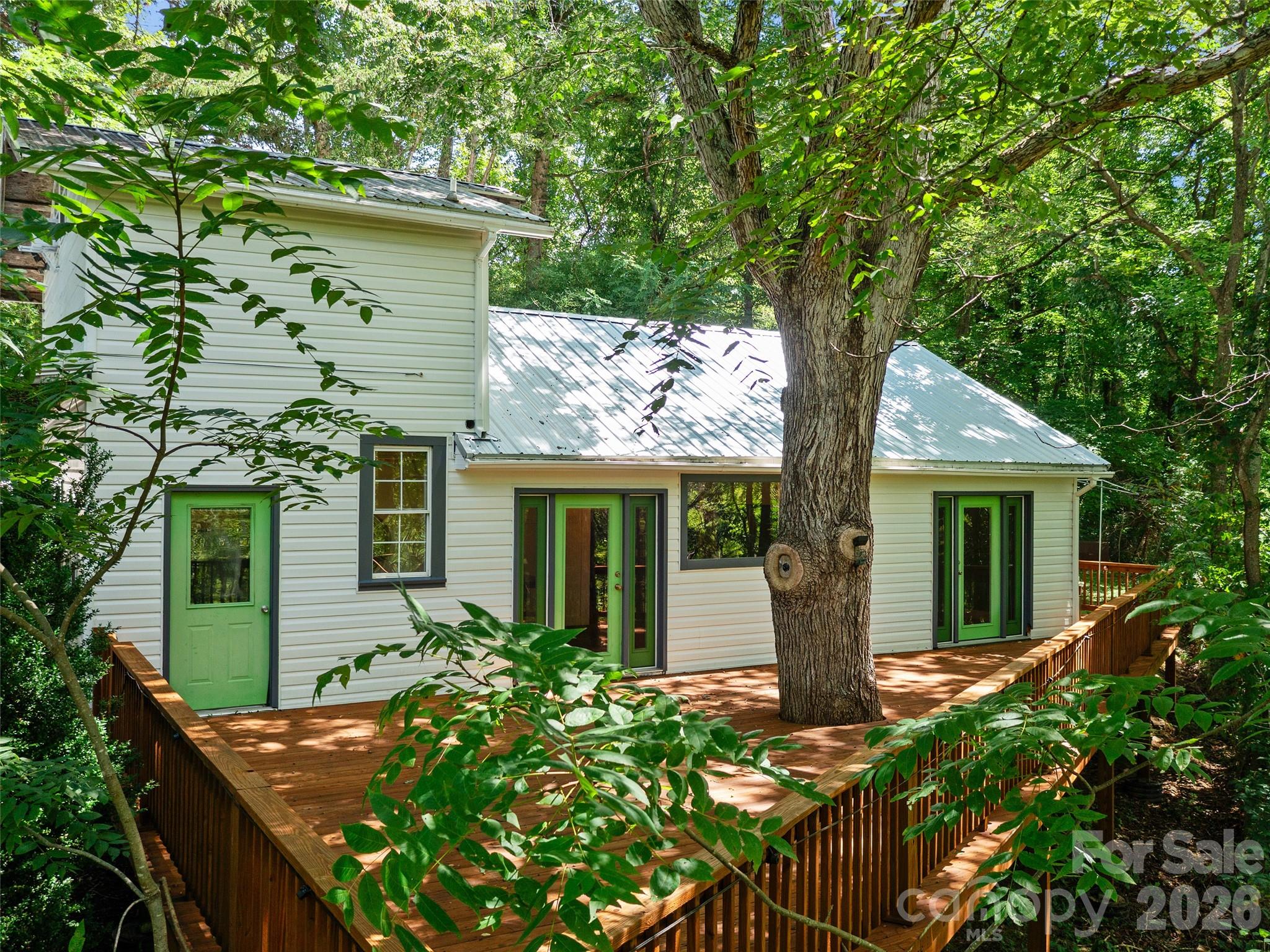 Experience the beauty of the South Toe River Valley in this charming 2BR/2.5BA mountain retreat - offered below recent appraised value! The home features large windows that frame picturesque mountain views, creating a warm and inviting atmosphere throughout with nice natural light. The kitchen is equipped with a propane gas cooktop and a new refrigerator (2026), while hardwood and slate tile floors add character and charm. Step outside to the expansive refinished deck and take in stunning views of Celo Knob - an ideal setting for relaxing, entertaining, or enjoying the peaceful mountain surroundings. The upstairs primary suite features a recently added full bath. The living room has been thoughtfully converted into a movie theater, enhancing the home's appeal as a full-time residence, vacation getaway, or investment property. Most recently rented for $1,800 per month, the property offers proven income potential. Additional highlights include a new metal roof (2025), covered carport/outdoor entertainment area, storage shed, and fruit trees. Conveniently located with easy year-round access just off US-80 South, this unique mountain home combines comfort, character, income potential, and breathtaking scenery in one of the area's most sought-after locations.