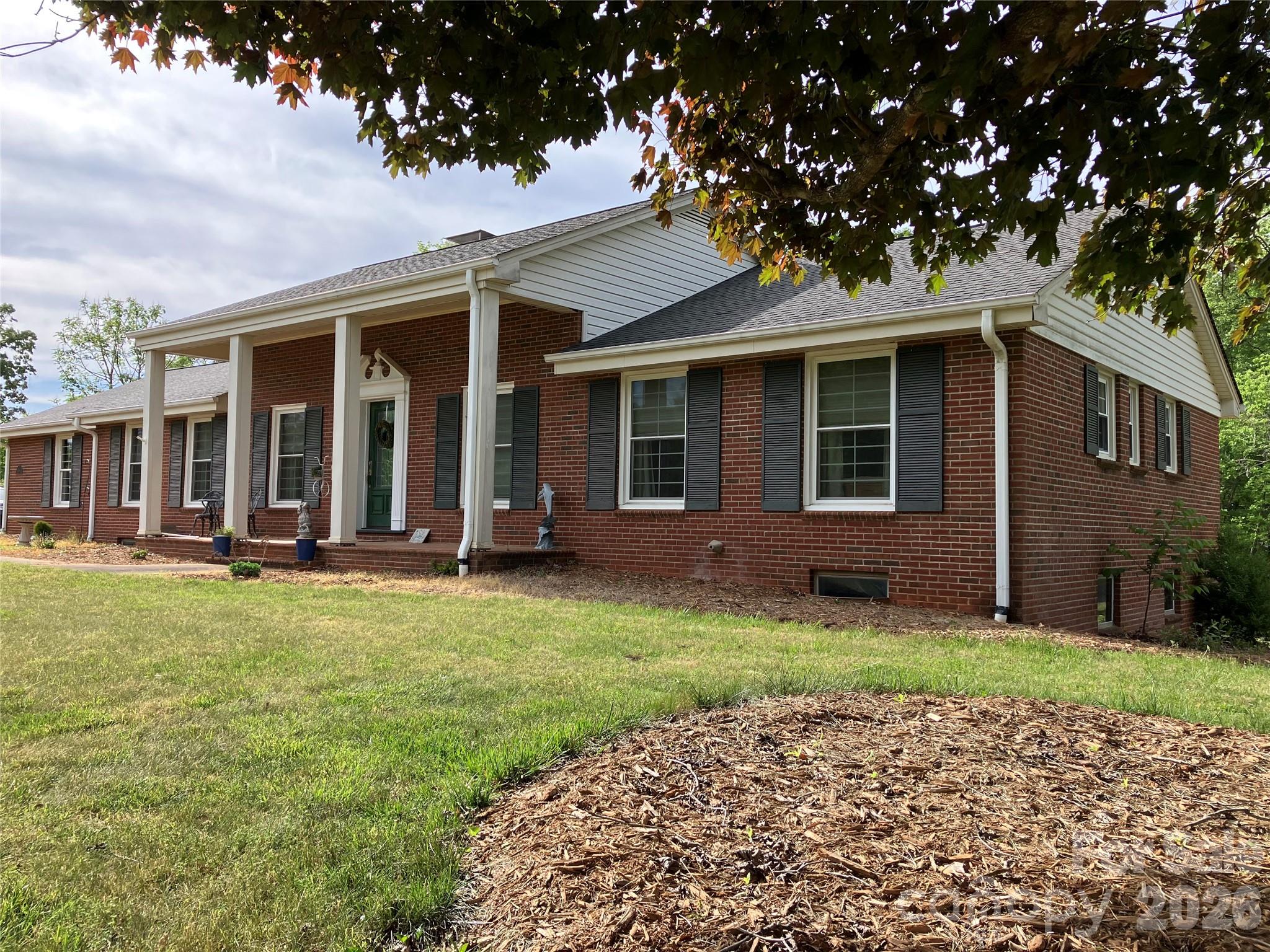 Recently remodeled brick home on a desirable corner lot with mature trees, large yard and a 2-car attached garage. Close to town, but not in-town. The neighborhood primarily consists of similar size, well-maintained homes, also with large yards.
The large primary bedroom has its own attached bathroom with a custom tile shower, separate tub and a walk-in closet. Full-glass enclosed back porch is an inviting and unique space; a relaxing place to spend time year-round. Attached deck with access off the porch and dining area makes for easy alfresco dining or entertaining.
 Library / reading area with large built-in bookshelves. Fully updated kitchen with double ovens and a gas cook-top.
 Kitchen and laundry appliances are almost new and are included. Large (2091 square feet!) of walk-out basement space (not included in the heated square footage) that was set up as a separate apartment at one time and could be set up that way again if desired. Workshop and plenty of basement storage in the home. Detached garage with carport that could be used as an additional workshop and/or additional garage/shop space.

 The sale will include a portion of the adjacent lot that contains the detached garage and about 30' of additional yard alongside the the length of the driveway. Total acreage will be about 1.48ac combined. (see pictures for outline of the new lot).