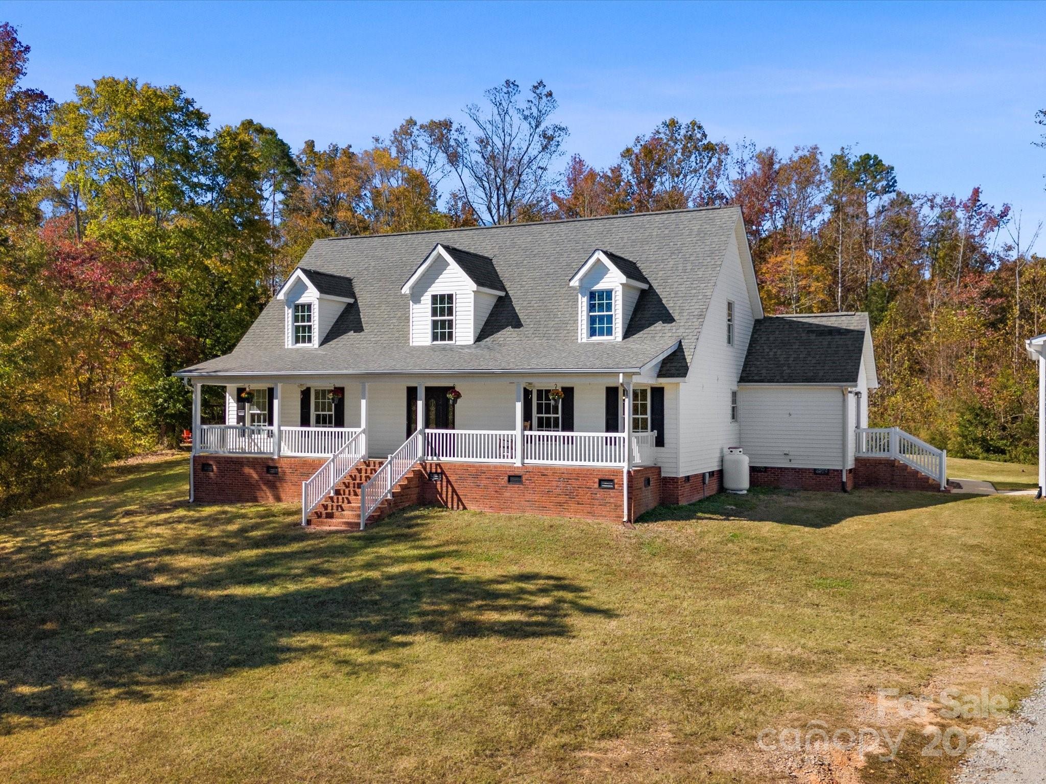 COME SEE THESE VIEWS! Welcome to your Farmhouse in the country w/ over 18 acres and large 3 car garage/workshop! Every room is oversized and comfortable in this character filled home! Eat-in kitchen features breakfast bar for quick snacks while dining room provides seating for lots of guests. Living room boasts double sided gas fireplace, stone surround, sunroom shares the other side of fireplace. Sunroom is flooded with natural light and overlooks the in ground pool, fire pit and swing set. Primary ensuite on main newly renovated into a spa-like primary bath for relaxing! Separate soaking tub offers serenity after a long day. Beautiful hardwood floors have been recently refinished in foyer, living, dining, and primary bedroom. Storage galore with 2 entry closets off front foyer, walk-in attic storage off both upstairs bedrooms and great closet spaces. Room at top of stairs is flex room for an office or TV area! Enjoy rocking chair front porch and rear deck overlooks pool. Don't miss!