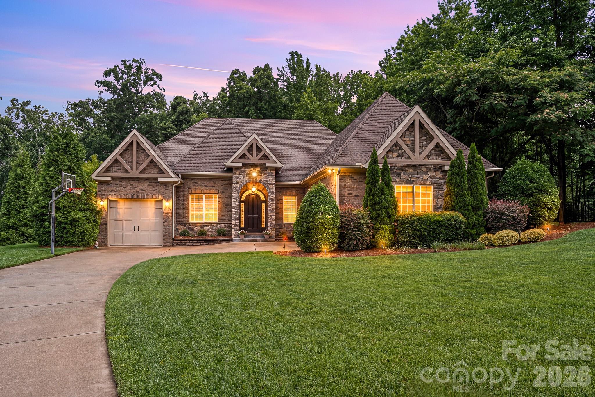 Experience the Pinnacle of Luxury in this Custom-built Masterpiece, perfectly situated within Weddington’s coveted Bromley community. This residence sits on a sprawling 1.21-acre private, wooded lot, featuring a stunning Hardscaped Koi Pond and a side-loading 3-car garage. Exquisite Design & Craftsmanship step inside to find Designer touches at every turn, from Artful lighting and Rich hardwood flooring to Soaring Coffered ceilings. The Grand Great room boasts a floor-to-ceiling fireplace and a breathtaking wall of windows that floods the home with natural light. A Chef’s Dream The Gourmet Kitchen is a showstopper, equipped with an Oversized Social Island and Handcrafted Cabinetry,Premium countertops and Professional-grade stainless appliances, a walk-in pantry and a butler’s pantry complete with a wine refrigerator—Perfect for Entertaining. Seamless Indoor-Outdoor LivingRetract the accordion doors to blend the interior with a Luxurious Covered Patio, featuring its own fireplace for year-round enjoyment of the Serene, Wooded backyard. Sophisticated Living Spaces Main Level Primary a true sanctuary with a Spa-inspired bath featuring a soaking tub, walk-in shower, double vanity, and a massive custom closet. Accommodations Two Large Secondary bedrooms with a Jack-and-Jill bath are located on the main floor, alongside a Private office and Formal Dining room. Second Level a massive Secondary living space with endless storage, an additional Owner's Suite with a Private study, and a Versatile Bonus room that can easily serve as a 5th bedroom. This home combines Architectural Elegance with a versatile floor plan, offering unparalleled Privacy in one of Weddington's most Prestigious Enclaves.