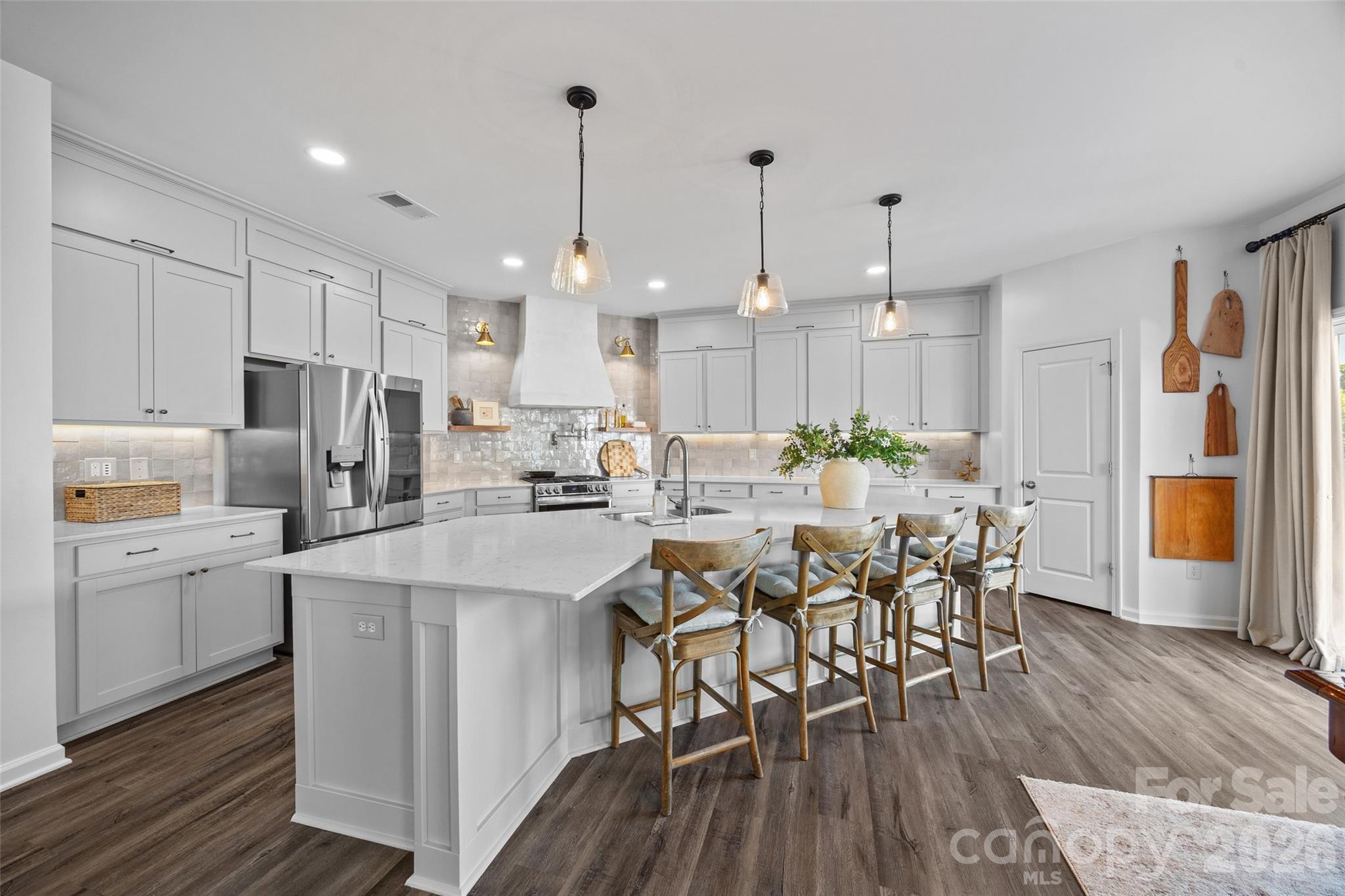 There is no shortage of show-stopper finishes at this designer home! From the moment you enter from the covered front porch, luxurious details abound - including upscale lighting, tons of added trim work, custom shades and blinds, added lighting features, and more. LVP flooring runs throughout the main level, and at the front of the home is an office with french doors, and dining room. The open and bright floor plan leads you into a great room with cozy gas fireplace. Every space was used, with the under stair area converted to a fun play/pet/storage area. You can't help but be in awe of this chef's kitchen - the glistening backsplash, custom hood, gas cooking, upgraded appliances, solid pantry shelving, tons of storage space including cabinets to the ceiling, and extra details such as the pot filler and under cabinet lighting. As you head upstairs, you'll find a large bonus room, which could also be a bedroom, as well as another 3 secondary bedrooms which are all spacious. Another 2 secondary bathrooms, with the theme of custom touches continue. And then you'll find the primary suite which will blow you away - luxurious wallpaper, the added trim continues, and into the bathroom which was completely remodeled to feature a walk-in tiled shower with river rock shower pan, dual shower heads, stunning vanity, and a resized custom closet to give you loads of storage - there is no detail left untouched at this home! As you continue to the 3rd level you'll find the most fabulous media room, set up perfect for movie nights and entertaining. Even with another office space to make use of every space. A secondary bedroom and full bathroom round out this level, giving lots of layout options. The outside matches the inside with more custom features, including a large patio, the perfect fire pit spot, string lighting, fully fenced and also added privacy border, and a well maintained lawn! Every detail has been thought of, including a hidden trash area on the side of the home, smart features throughout, new carpet was put in, and even the garage was done with epoxy, added cabinets, heater, and completely finished walls and ceilings - nothing to do but move right in! And to make it even better, the community boasts a pool and cabana area, as well as fitness center, picnic area, streetlights, and sidewalks. Literally straight from an interior design magazine, don't miss your chance to make this one-of-a kind home your own!!