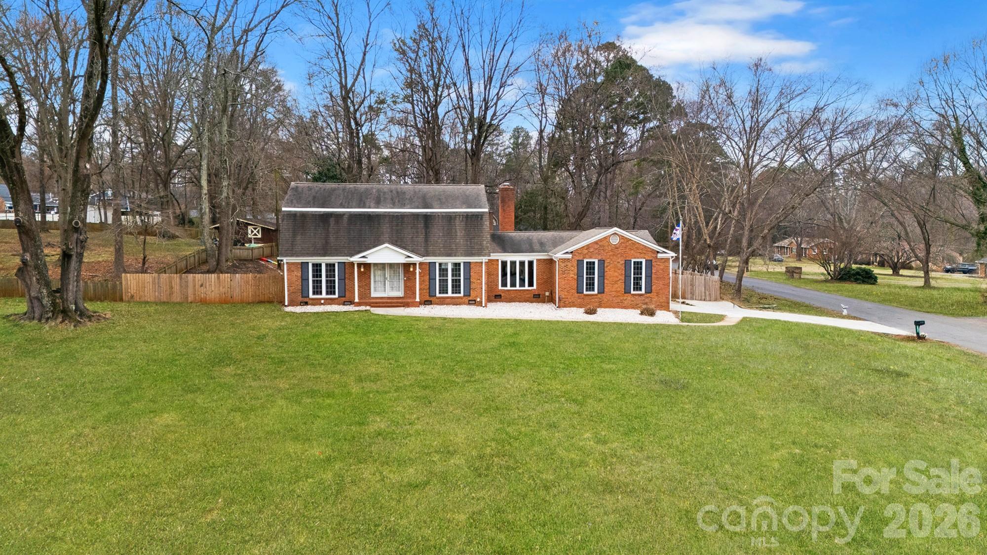 Welcome home to Farmwood - one of Mint Hill’s most desirable neighborhoods. Located on more than an acre of land with a golf course view, this full brick, 4 bedroom, 4 bath home features TWO primary bedrooms, a fenced back yard, storage shed and a greenhouse for all your gardening needs. Step inside to the entry hall where you will find a generous size formal dining room that opens to the well equipped kitchen, cozy great room, and one of two primary suites featuring a private bath and walk-in closet. A second full bath, conveniently located laundry room and mudroom entry off the garage completes the main level. On the upper level you will find the second primary suite with a private bath and walk-in closet, 2 generous size secondary bedrooms and a full hall bath. There are plenty of storage closets throughout the home plus a two car side load garage provides additional storage along with a storage shed and a greenhouse. Enjoying the outdoors is easy from the patio overlooking the fenced back yard or golf course views from the front porch. There is no HOA but buyers can inquire about membership costs at Pine Lake Country Club directly across the street. Great location positioned between  Mint Hill and Matthews giving you quick access to both downtown areas where you can enjoy walking to outdoor dining spots & farmers markets!