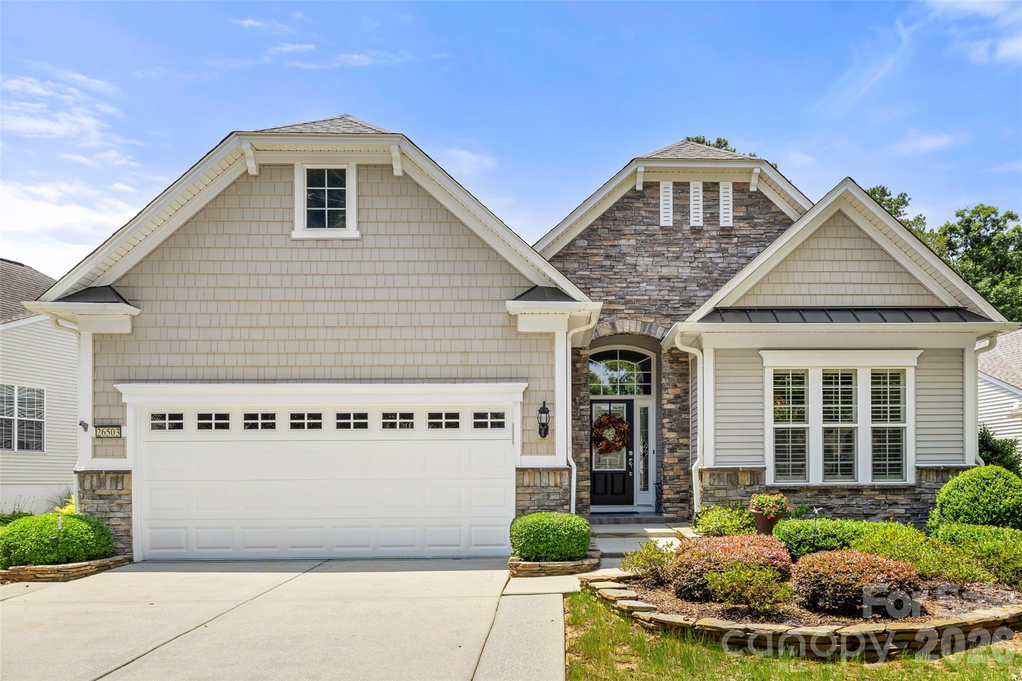 Beautifully maintained home in Sun City Carolina Lakes with elegant finishes, spacious living areas, and a bright sunroom filled with natural light. The main level features crown molding, wood flooring, plantation shutters, and an inviting flow for everyday living and entertaining. The kitchen offers white cabinetry, granite countertops, tiled backsplash, stainless steel appliances, center island, and a pass through to the dining area. The great room with a gas fireplace opens to a bright sunroom surrounded by walls of windows. Just beyond, the inviting three-season room features a vaulted beadboard ceiling, providing the perfect space to enjoy the outdoors year-round.  Step outside the 3-season room to a deck with retractable awning; perfect for grilling.  The primary suite features a tray ceiling, dual vanity, and custom tiled shower. The finished basement offers flexible space for recreation, hobbies, office, fitness, media, guest use, or storage. A large patio offers another great outdoor living space for entertaining or peaceful nights. A charming home with timeless details in the sought-after Sun City Carolina Lakes community.