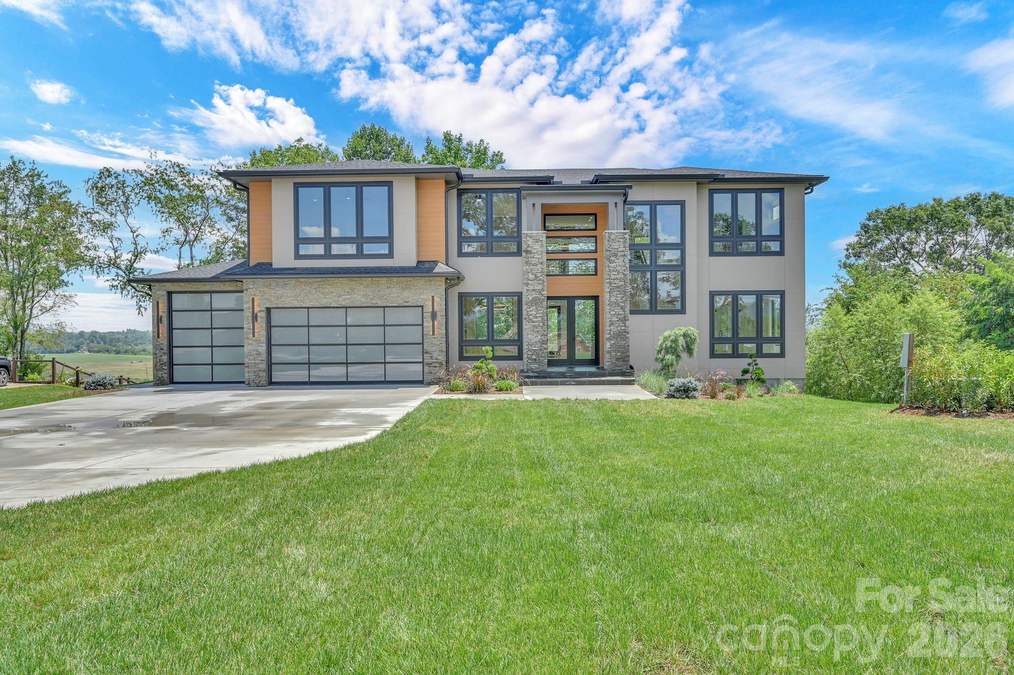 Your modern masterpiece awaits.  This stunning new-construction home was designed around panoramic mountain views – both close and long-range.  Plentiful windows saturate every room with natural light and allow you to indulge in the spectacular scenery from any spot in the home.  As you step through the front door, a dramatic two-story foyer welcomes guests and sets the tone for the home's sophisticated design.  The open-concept floor plan flows seamlessly into the grand two-story great room.  This breathtaking living space is adorned with incredible walls of glass and a floor to ceiling fireplace that must be seen to be believed. The kitchen is a chef’s dream featuring Viking and Sub-Zero appliances, custom cabinetry, and an oversized island perfect for entertaining and gathering with family and friends.  This residence features two luxurious primary suites – one on the main floor and one upstairs – both with spa-inspired ensuite baths and spacious walk-in closets. The two primary bedroom design offers maximum flexibility for potential multi-generational living or as a luxury suite for your guests to relax. Conveniently, laundry rooms are located on each floor for added functionality.  The expansive three-car garage has an epoxy coated floor and provides exceptional options for storage and versatility. Uniquely, this garage features an oversized door and bay that would be perfect for accommodating a boat, RV, or collection of vehicles. The thoughtful design of this home makes it one of a kind – combining modern elegance with effortless livability to form a truly extraordinary retreat.