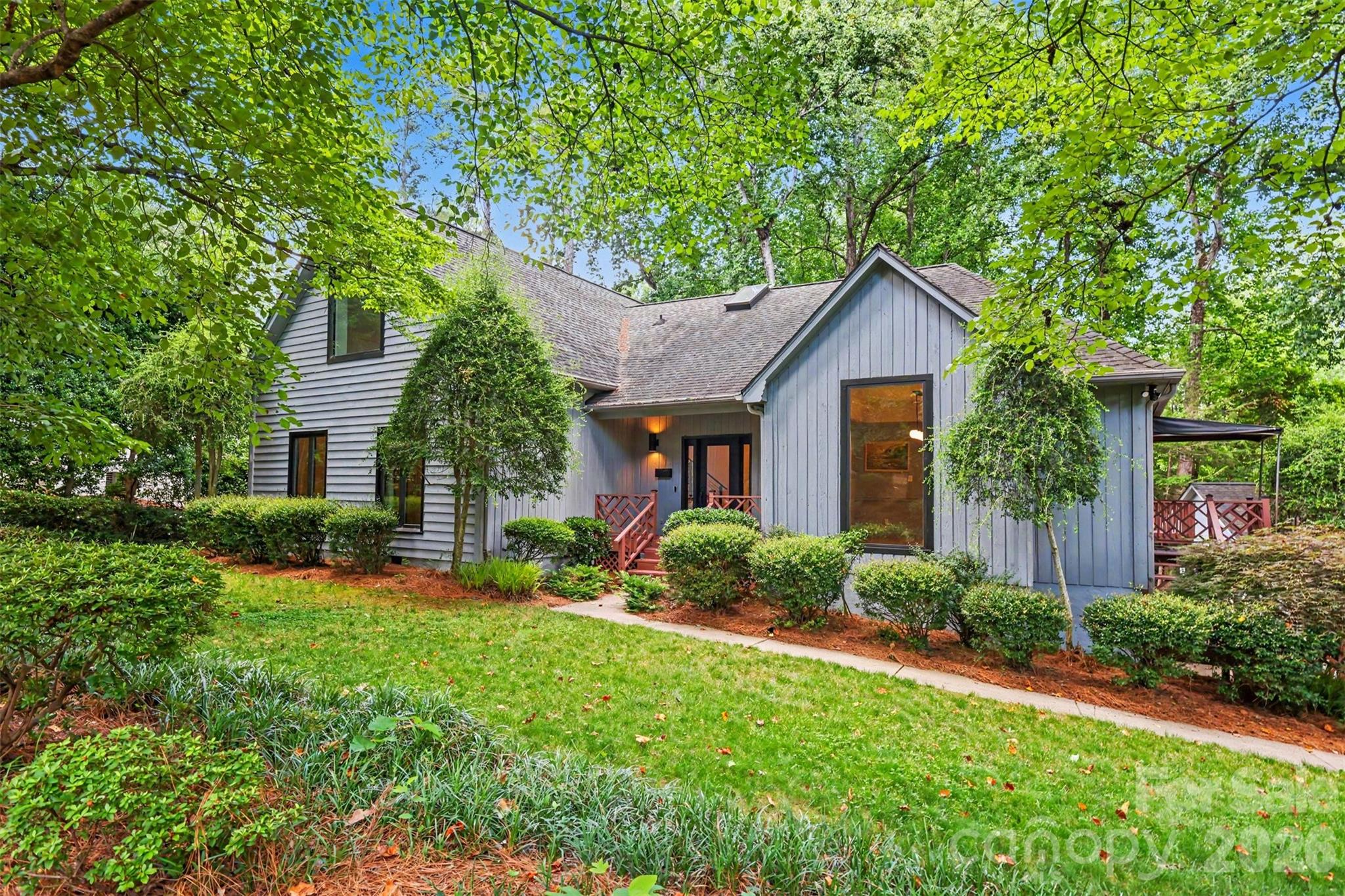 Set on a generous wooded lot in the highly sought-after Cotswold neighborhood, this beautifully updated 1.5-story residence blends timeless architecture with a bright, modern aesthetic and an exceptional sense of privacy. A welcoming front porch and mature tree canopy set the tone for the home’s warm curb appeal, while inside, vaulted ceilings, expansive windows, and an open flow create a light-filled atmosphere throughout the main living spaces.
The main level is designed for both everyday living and effortless entertaining, with a spacious great room anchored by a fireplace and framed by French doors that open to outdoor areas. The gourmet kitchen serves as the heart of the home, featuring a large central island, clean-lined cabinetry, and seamless connection to dining and living spaces. The primary suite is thoughtfully positioned for privacy and offers a serene retreat with a spa-inspired bath and generous closet space, while additional bedrooms provide flexibility for guests, home office use, or multigenerational needs. A bonus upper level adds valuable additional living space, ideal for recreation, media, or work-from-home versatility.
Outdoor living is a standout feature, with a large deck overlooking the wooded surroundings, creating a peaceful backdrop for morning coffee or evening gatherings. The property also includes both attached and detached garage options, adding convenience and flexibility rarely found in this location.
Situated in the heart of Cotswold, the home offers easy access to some of Charlotte’s most desirable amenities. Residents enjoy proximity to Cotswold Village shopping and dining, nearby greenways and parks, and a quick commute to SouthPark, Myers Park, and Uptown Charlotte. The home is also zoned for Billingsville Elementary, Alexander Graham Middle, and Myers Park High School, placing it within one of the city’s most established and well-regarded school corridors.
This is a rare opportunity to enjoy a private, wooded setting with fully updated interiors in a premier Charlotte location that continues to be one of the city’s most enduring and convenient neighborhoods.