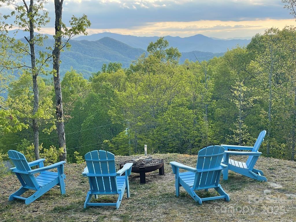 Escape to Cooper's Ridge, where mountain luxury meets effortless serenity. Set atop 3,400 ft in gated Alarka Creek Properties, this contemporary retreat captures top-of-the-world views & ultimate privacy. Sunlight fills the open living space, where a striking double-sided fireplace, enhanced with one-of-a-kind custom sheet metal surround, glows between the living, dining & kitchen areas. The chef’s kitchen blends modern design with timeless warmth, perfect for gathering with friends. Unwind in the private primary suite with its sitting area, deck access & spa-worthy bath. Two inviting guest rooms share a tiled Jack & Jill bath with 1/2 bath access for guests in the main living area. Outside, café lighting twinkles over the covered deck, hot tub & fire pit under the stars. Practical luxuries include a whole-house generator & HOA-approved architectural plans for a 2.5-car garage. Whether a peaceful escape or a successful vacation rental, this turnkey mountain haven invites you to slow down and savor the view.  The driveway is scheduled to be paved mid-June at the sellers' expense.
