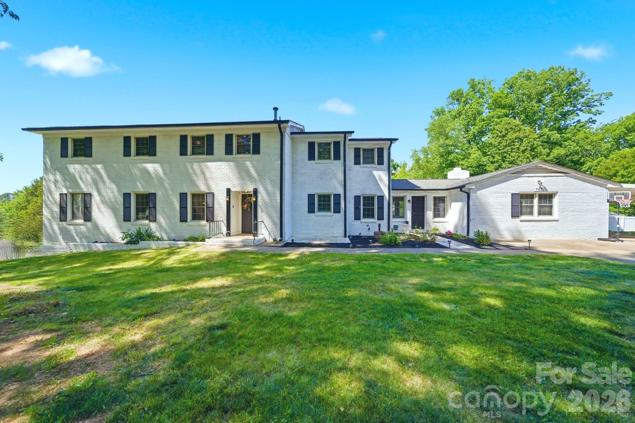 Spacious two-story house on a generous 0.69-acre lot in established Bessemer City, offering 3,031 sq ft of living space plus a full basement for storage, workshop, or future finished space. Thoughtfully laid out with 4 bedrooms and 3.5 baths, including a main-level bedroom and full bath — ideal for guests, a home office, or single-level living needs. The upper-level features 3 additional bedrooms and 2 full baths, providing plenty of room to spread out. Enjoy classic mid-century craftsmanship with the timeless durability of solid brick construction, an attached carport, and a concrete driveway. Situated on a large lot with mature surroundings, this home delivers the rare combination of square footage, land, and location — just minutes to downtown Bessemer City, Kings Mountain, and an easy commute to Gastonia and Charlotte via I-85.
