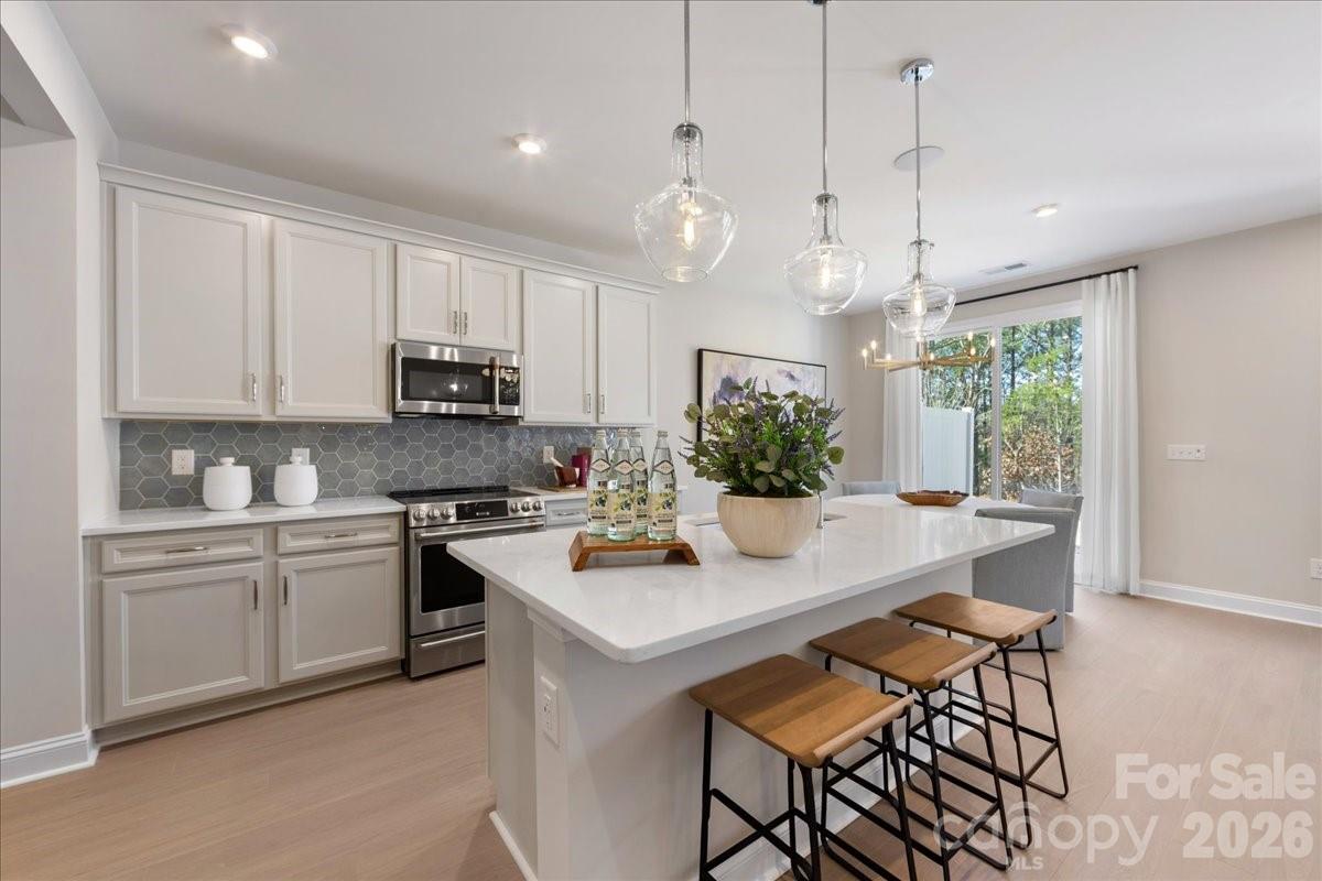 Bask in the best of Camryn at Southbridge at 201 Landy St in Fort Mill, SC, where scenic walking trails, a community playground, and thoughtfully designed new construction townhomes come together in a highly desirable location near Kingsley Town Center, Anne Springs Close Greenway, and top-rated schools. This Falcon plan offers elevated townhome living with a gourmet kitchen featuring white cabinets, white quartz countertops, GE 36" gas cooktop, large single-bowl stainless steel sink, Brushed Satin Nickel hardware, and a Cabinet Convenience Package designed to enhance storage and everyday functionality. Tray ceilings in the foyer and primary bedroom add architectural detail with tray ceilings, while oak box stairs with open rails bring a modern, open feel to the home’s interior. An 8-foot by 8-foot sliding glass door expands the living space to an 8x8 outdoor living area, creating seamless indoor-outdoor flow with serene, tree-lined views. A convenient drop zone near the garage entry supports effortless daily organization, while laundry access directly from the primary walk-in closet adds thoughtful functionality to everyday living. Positioned with no neighbors in front or behind and located near the community trail entry, this home offers rare privacy within a connected Fort Mill townhome community. The primary bathroom continues the elevated design with white cabinetry and white quartz countertops for a clean, spa-inspired finish. Photos are representative of the Falcon floor plan. Anticipated move-in date of October 2026