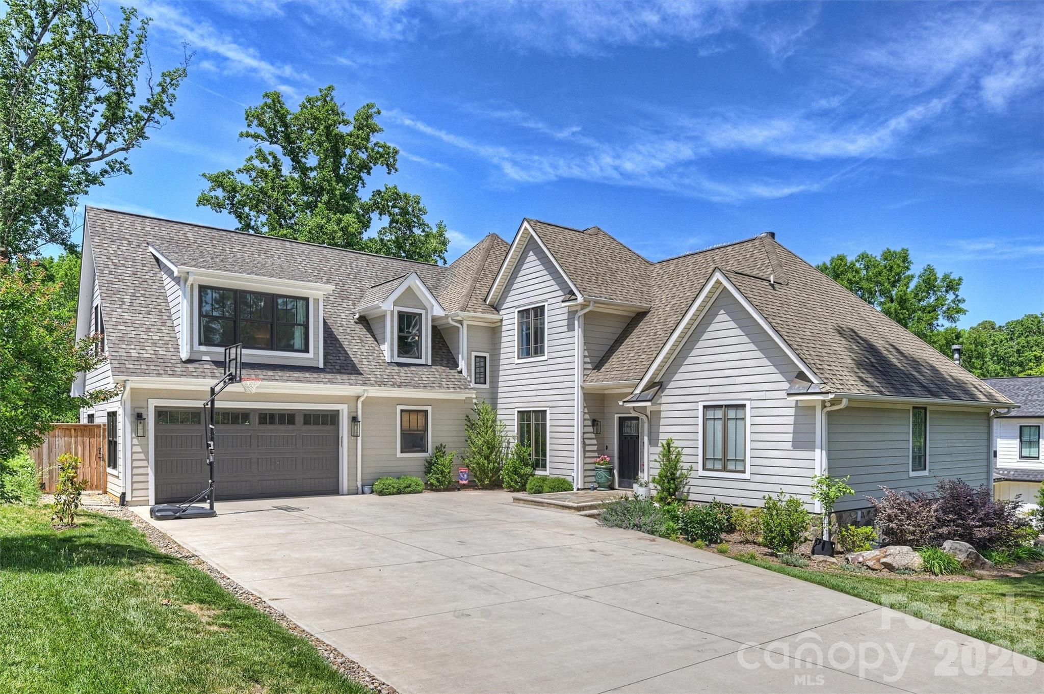 Welcome to 237 Hunter Lane, a thoughtfully updated home offering exceptional space, functionality, and outdoor living. In 2023, the home underwent a significant expansion adding two bedrooms, a full bath, a spacious drop zone, and an attached two-car garage—creating a layout designed for today’s lifestyle.
The main level features soaring ceilings throughout the living areas and primary suite, creating a bright and open feel. At the center of the home, the kitchen offers a large island with breakfast bar seating, an oversized breakfast nook, and additional space for club chairs or casual gathering. An oversized scullery and pantry provides exceptional storage and prep space. Just off the garage entry, the drop zone includes a built-in desk, large bench, and ample hanging storage for everyday convenience.

The primary suite on the main level offers both privacy and ease of living, while the flexible floor plan includes six total bedrooms, including one in the walk-out basement—ideal for guests, a home office, or additional recreation space. The basement serves as a true extension of the home with a large entertaining area, secondary living room, and private bedroom suite.

Outdoor living is equally impressive with both an uncovered deck and a spacious, covered screened porch with fireplace. Designed to accommodate both dining and lounge areas, the porch overlooks the beautifully sized .37-acre yard with plenty of usable green space.  With proximity to Cotswold Shopping Center, Uptown and Southpark, this home offers the perfect blend of privacy and proximity.