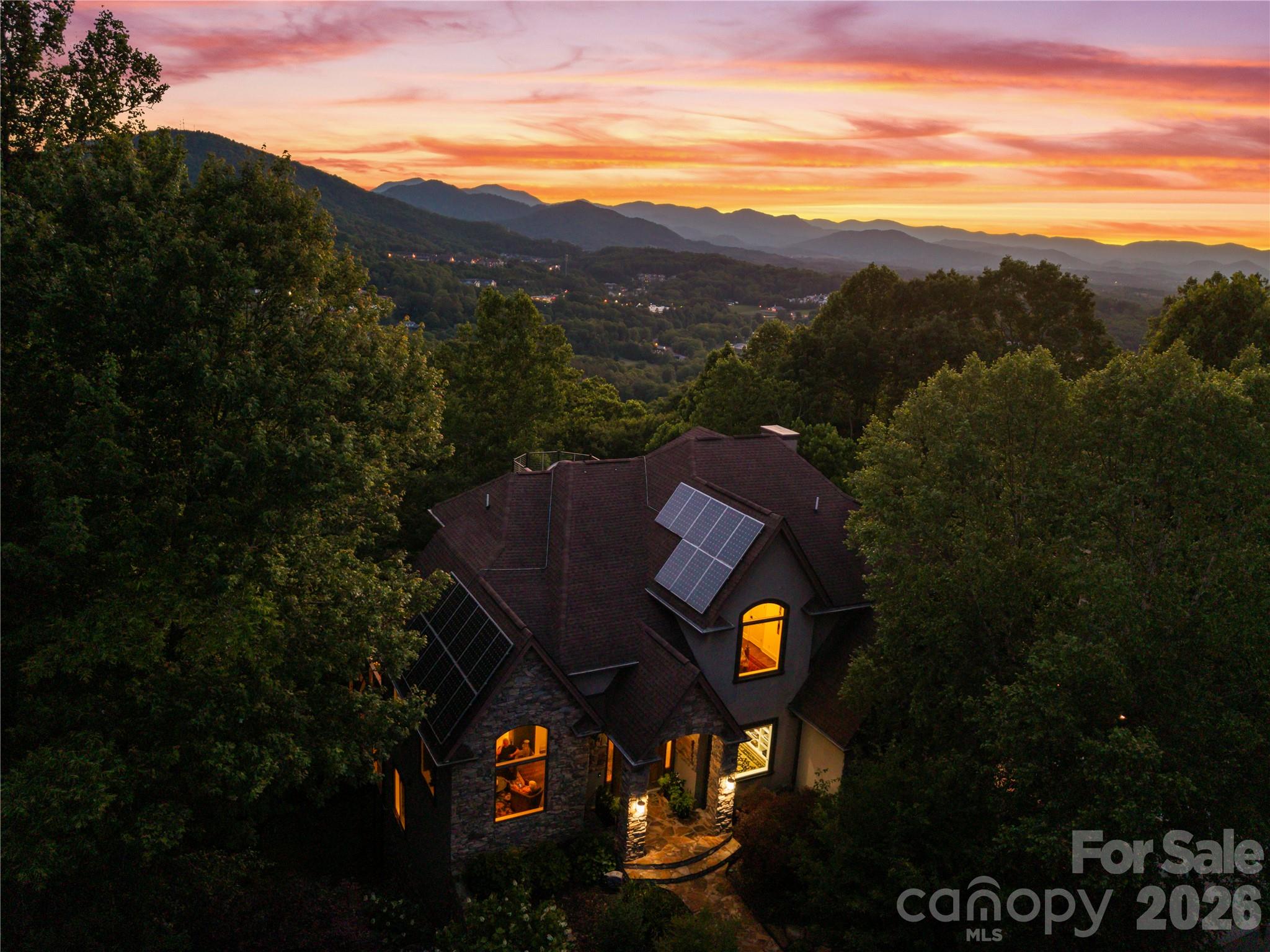 Charming, light-filled residence in Chimney Crest offering elevated mountain views and thoughtful upgrades throughout. This home welcomes you with a covered front porch and a bright foyer leading to an airy living room with vaulted ceilings and a stone fireplace. The updated kitchen features granite counters, high-end appliances, a breakfast bar, and a cozy breakfast nook that opens to one of the viewing decks perfect for morning coffee, the ideal morning spot. Generous primary suite with ensuite bath and walk-in closet plus two additional bedrooms and a dedicated home office or craft room. Finished lower level provides a family room, guest suite option, and walkout access a private deck. Recent improvements include new HVAC, refreshed paint, and upgraded bathrooms. Three-car garage, smart-home features, photovoltaic solar power with credit, and ample storage. Close to schools, shopping, and outdoor trails, this home combines convenience with peaceful neighborhood living and easy access to all Asheville has to offer.
