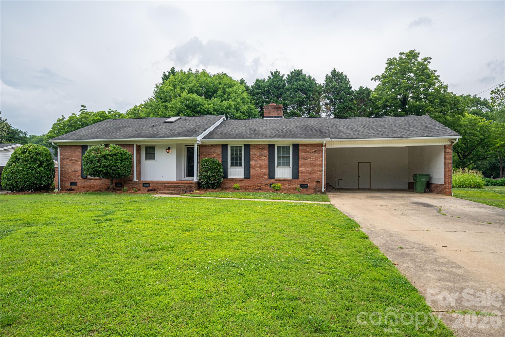 Welcome Home to Woodland Park! This brick ranch is situated in an established neighborhood with NO HOA. Featuring 3 bedrooms, and 2 baths, this home boasts classic character, ready for its new owners. Enjoy the peaceful back yard while sitting on your screened in back patio, your morning coffee on the front porch, or cozy up by the fireplace in the living room. The kitchen has plenty of original wood cabinets and counter space. The attached car port offers lots of space, and could easily be converted into a garage. It also has a large utility closet. The HVAC was replaced in 2024. Enjoy the classic style that this home offers, or make it your own! The possibilities are endless. This home is in a great location, with close proximity to restaurants in downtown Mount Holly,  Hwy 16, and I-85.
