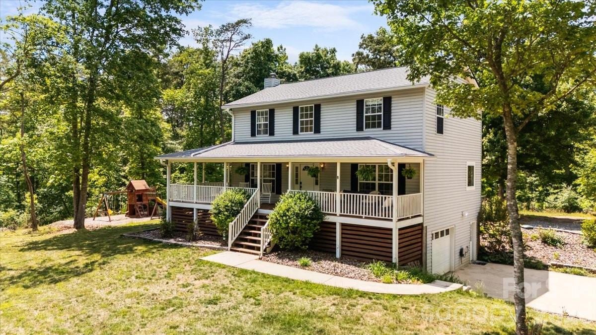Tucked perfectly between Weaverville and Mars Hill, this 6-bedroom, 3.5-bath home offers the perfect balance of privacy, space, and convenience on 5 beautiful acres of flat, usable land. A scenic drive along the river leads to the tree-lined driveway, setting the tone for a property that feels both peaceful and inviting. The land offers fenced yard area, mature shade trees, and expansive outdoor space ideal for gardening, homesteading, recreation, or simply enjoying the mountain setting.

The wraparound covered porch is the perfect spot to start the day with morning coffee. Inside, the main level features a newly updated kitchen, spacious primary suite, renovated primary bath, and new flooring throughout. The lower level provides additional flexibility with its own living space, bedroom ensuite, bonus room ideal for a craft studio or workshop, separate entry for multigenerational living, and a one-car garage. Upstairs, you’ll find four additional bedrooms and a full bath, offering plenty of room for a growing family, guests, or hobbies.

Located in a welcoming community, the property does include a formal shared road maintenance agreement among neighbors. Combining usable acreage, a functional layout, privacy, and close proximity to town, this home offers a rare opportunity to enjoy mountain living without sacrificing convenience.