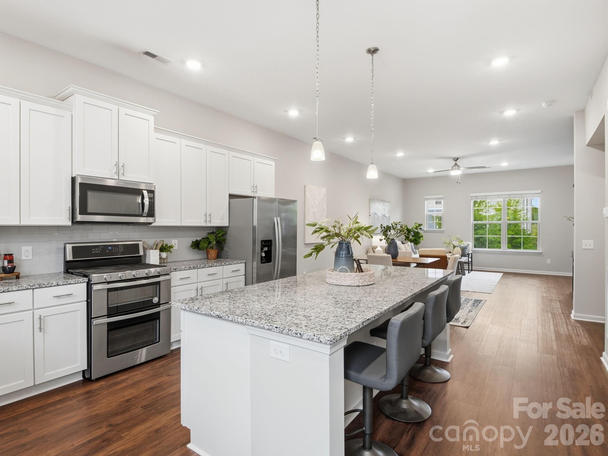 This is the kind of home that makes life feel easy. Located just around the corner from the light rail, this stylish 3-story townhome blends convenience, comfort, and low-maintenance living in all the right ways.
The entry level features a private guest suite with a full ensuite bath—perfect for visitors, a home gym, media room, or tucked-away flex space. The 2-car garage is equipped with a 240-volt charger, adding modern convenience right at home.

Upstairs, the open-concept main living area was made for gathering. The spacious kitchen features a huge island that flows seamlessly into the dining and living spaces, creating an ideal setup for entertaining, cozy nights in, or hosting game day with friends. Step out onto the balcony for morning coffee or an evening unwind.

The top floor offers three bedrooms, including a spacious primary suite and versatile secondary rooms that work beautifully as bedrooms, an office, nursery, or creative space. Brand new vinyl flooring throughout the main living spaces gives the home a fresh, updated feel.

Move-in ready with thoughtful spaces and an unbeatable location close to shopping, dining, and transit—this townhome is ready for its next chapter!