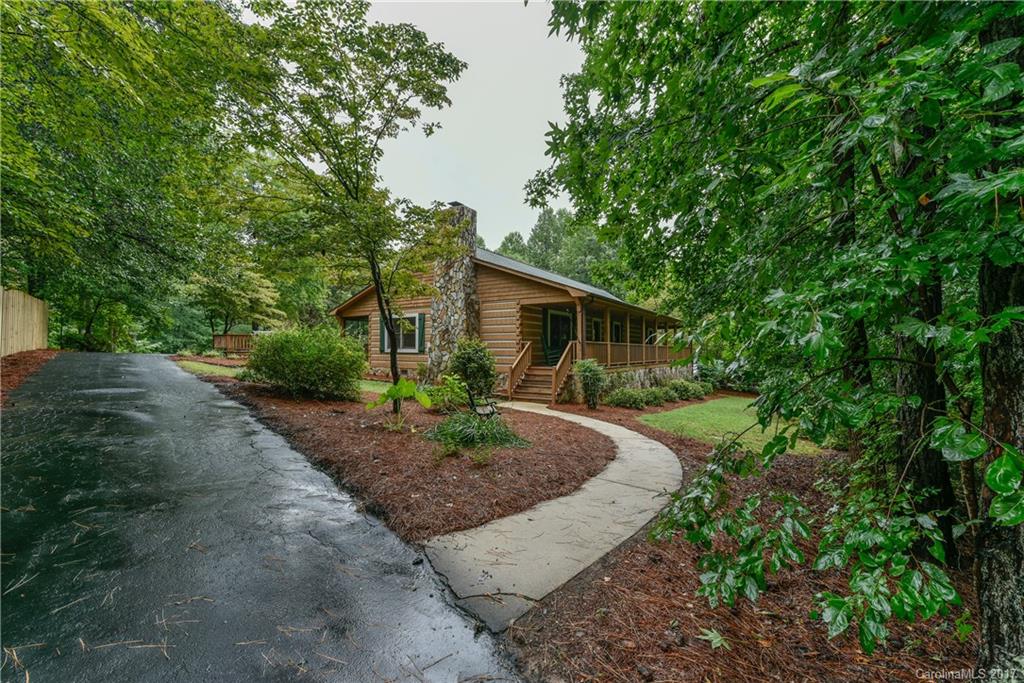 Private setting nestled on more than 2 acres.  Engineered log cabin that was built to perfection.  Quiet rustic atmosphere but yet close to everything.  Open floor plan with gorgeous fireplace.  3 detached garages perfect for the car enthusiast or hobbiest.  Relax on the rocking chair front porch, screened porch, back deck, or hot tub! Clean and move in ready.  Sought after Indian Land schools.  No HOA.  You will not be disappointed - this home is a must see.