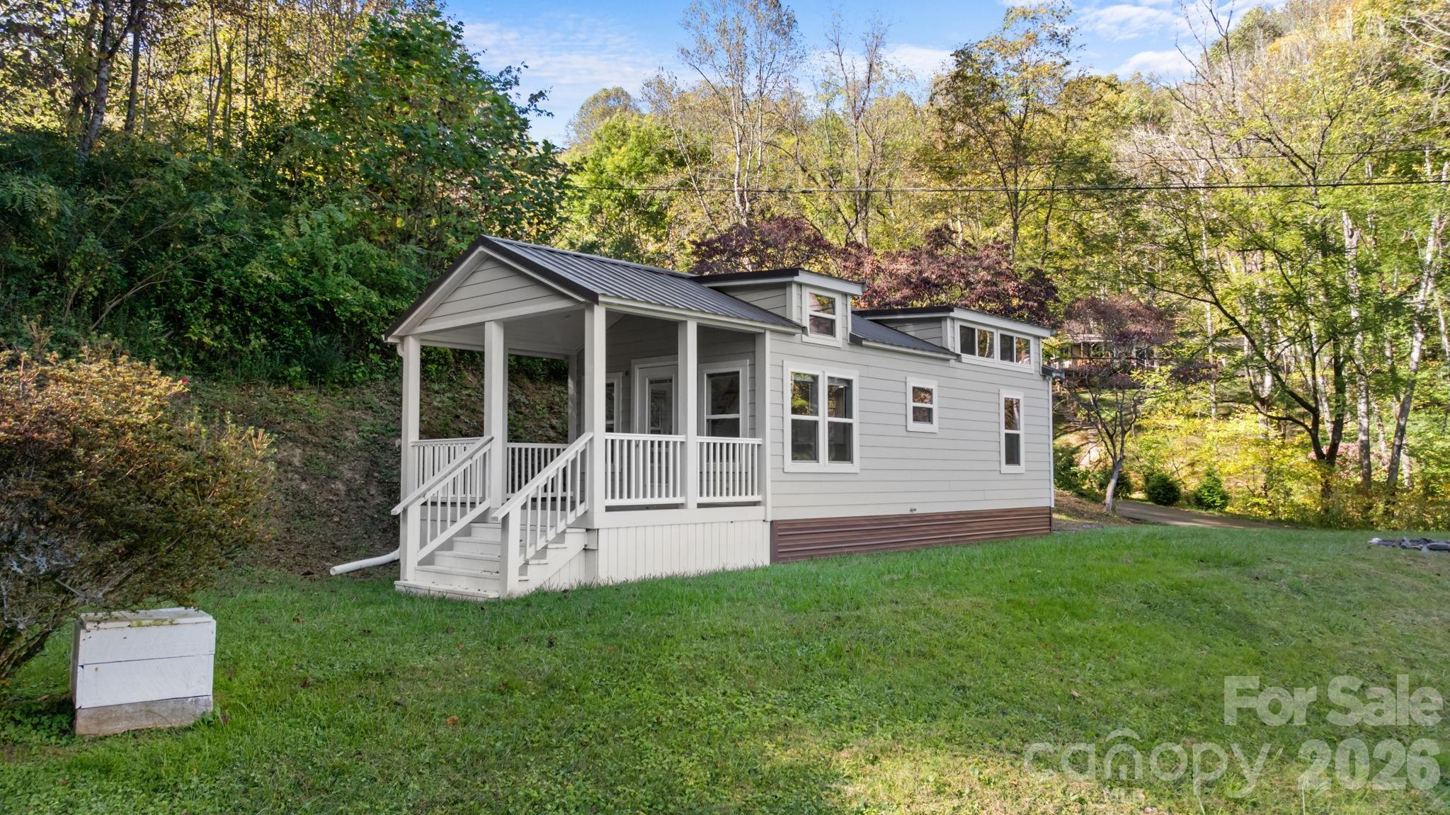 Discover the perfect blend of modern comfort and mountain serenity in this impeccably maintained 2021 Park Model. Situated on a private 0.2-acre lot, this home is designed for those seeking a low-maintenance lifestyle without compromising on breathtaking scenery.

The interior features a bright, open-concept floor plan that maximizes space and natural light. Strategically placed windows frame stunning, long-range mountain views, ensuring the beauty of Western North Carolina is a centerpiece of your daily life. Whether you are relaxing in the living area or enjoying your morning coffee on the inviting covered porch, the mountain vistas offer a peaceful escape from the everyday.

This property is equipped with a shared well and a shared septic system, providing a simplified approach to property management. The exterior grounds offer just enough space for a low-maintenance garden, outdoor fire pit, or peaceful landscaping to enhance your mountain retreat.

Ideal as a turn-key vacation getaway, a cozy downsizing opportunity, or a smart investment property, this home offers contemporary finishes and the ease of a newer construction build. Experience the quiet charm of mountain living—schedule your private tour today to see the views for yourself!