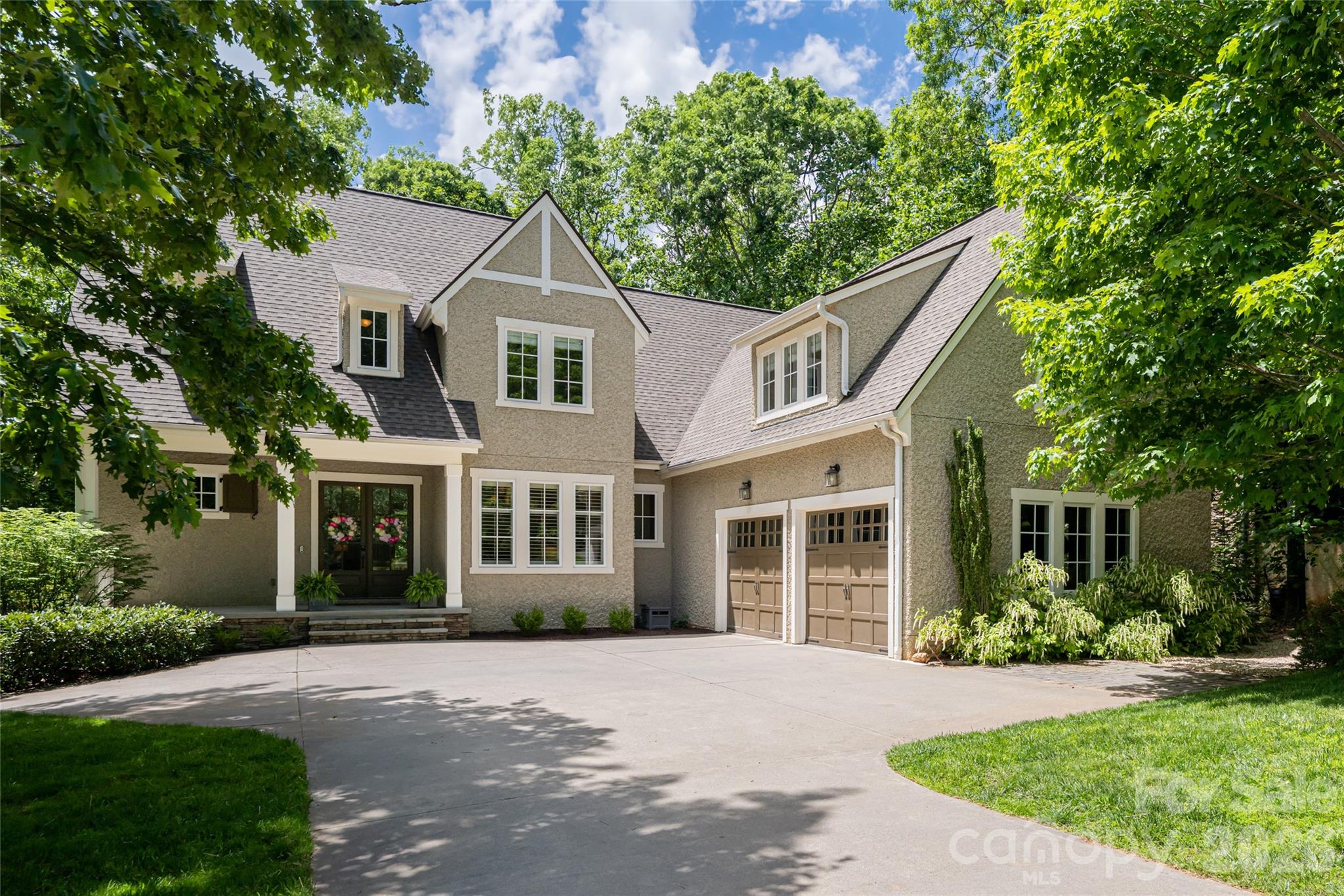Welcome to your dream home! Nestled in the gated Southcliff community just outside the Asheville city limits, this stunning escape offers a peaceful mountain setting while remaining minutes from downtown Asheville and the Blue Ridge Parkway. Reflecting the charm of Biltmore Village Tudor Revival style, this beautifully renovated home captures mountain views and blends comfort with style.

Step inside to a spacious, light-filled floor plan featuring an open living area ideal for entertaining. The modern kitchen is appointed with quartz countertops, a gas cooktop, updated lighting, and ample cabinetry. The main-level primary suite includes a renovated bathroom with a soaking tub. Upstairs, multiple bedrooms and flexible space provide options for a home office or game room. The walk-out basement adds versatility with a home theater, gym, and second office.

Outside, a flagstone patio and beautifully landscaped backyard abutting Southcliff’s protected conservancy area await—offering a tranquil natural backdrop and easy access to the outdoor lifestyle this area is known for.