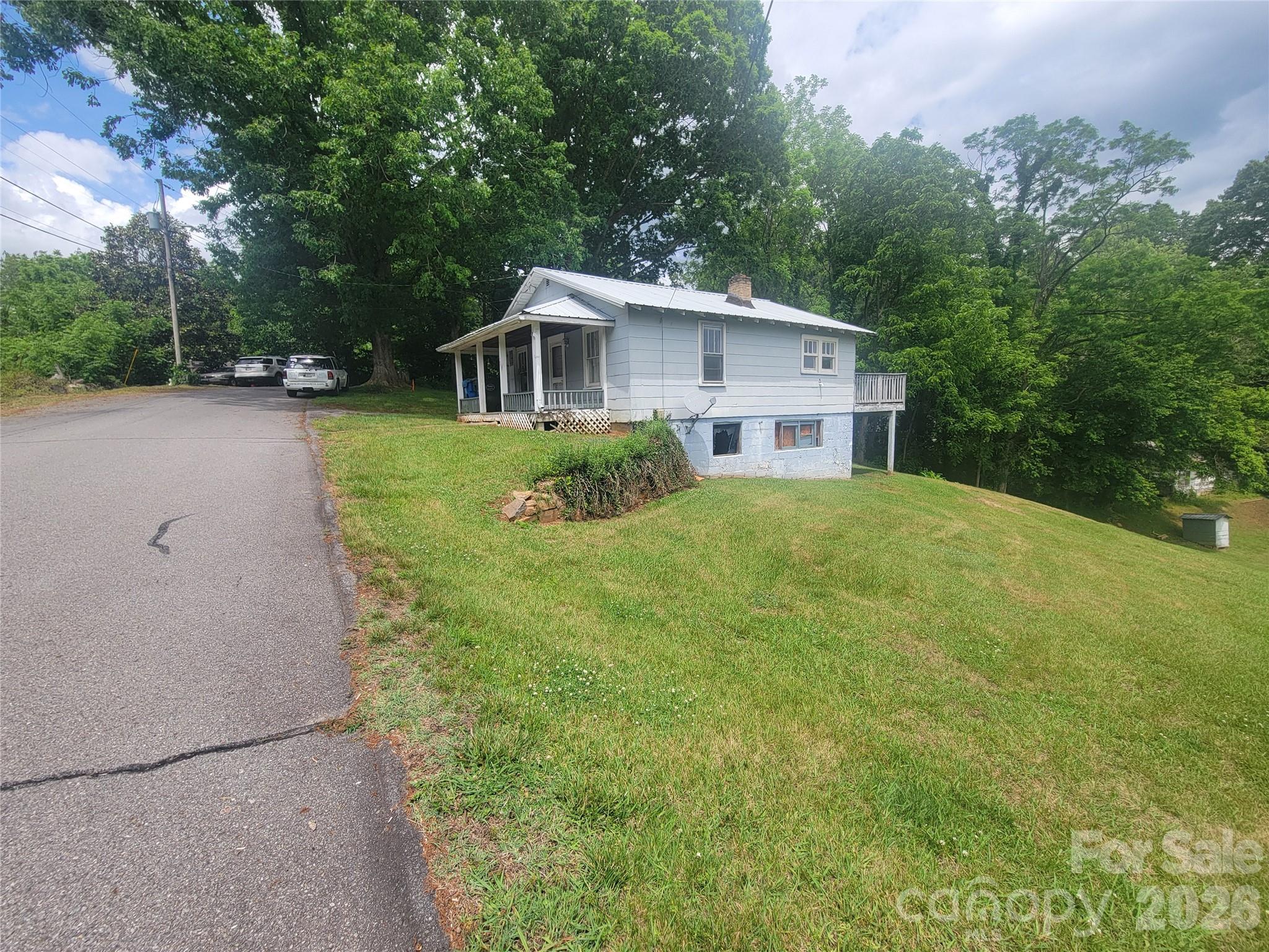 Excellent location minutes from Downtown Waynesville. Mountain views and a large yard. You can choose to fix this  2 bedroom, 1 bath fixer upper or choose to build a new home where city water and sewer are included. 0.285 acre lot allows 1/6th of an acre per home. Zoned in the Love Lane Neighborhood District.