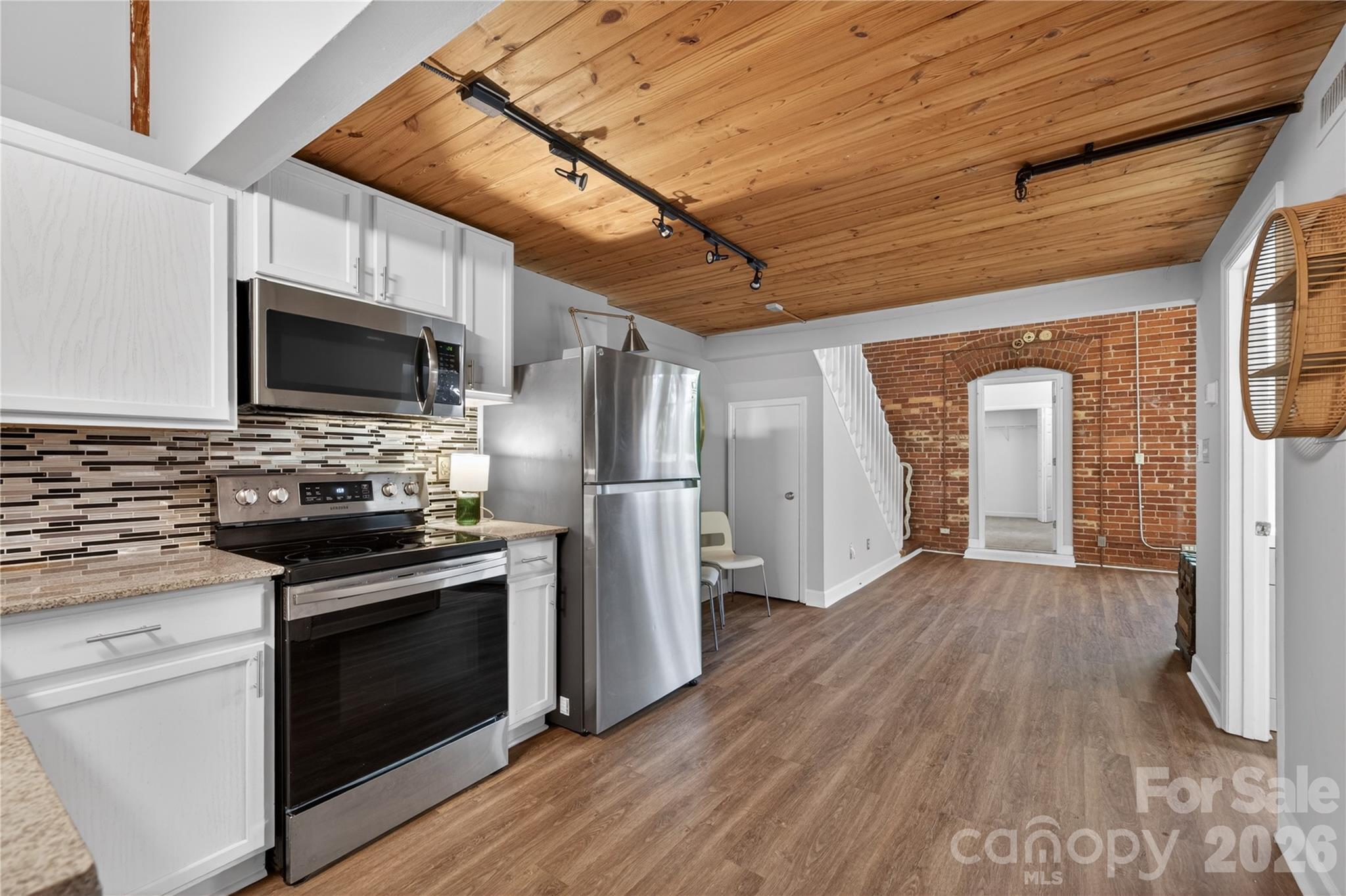 Own a piece of Charlotte history in the iconic Foxridge Lofts! This beautiful 2-bedroom, 1-bath loft blends historic character with modern style, featuring soaring 15+ foot wood-plank ceilings, exposed brick walls, oversized arched windows, and restored original wood stairs. The open-concept living area is filled with natural light and showcases the building's industrial charm. Please note: the original central HVAC system is currently not operational. The seller has installed a window A/C unit, which conveys with the property. The home is priced accordingly.

The renovated kitchen offers white cabinetry, granite countertops, stainless steel Energy Star appliances, stylish tile backsplash, and ample workspace. The bathroom features a modern vanity and tasteful finishes, while luxury vinyl plank flooring enhances the main living areas.

The spacious loft provides endless flexibility as a home office, media room, guest space, or potential third bedroom. 

Located just minutes from Uptown Charlotte, you'll enjoy the perfect combination of historic architecture and convenient city living. Foxridge Lofts is a unique converted mill community with secure building access, beautifully maintained common areas, and easy access to dining, entertainment, interstates, and everything Charlotte has to offer.