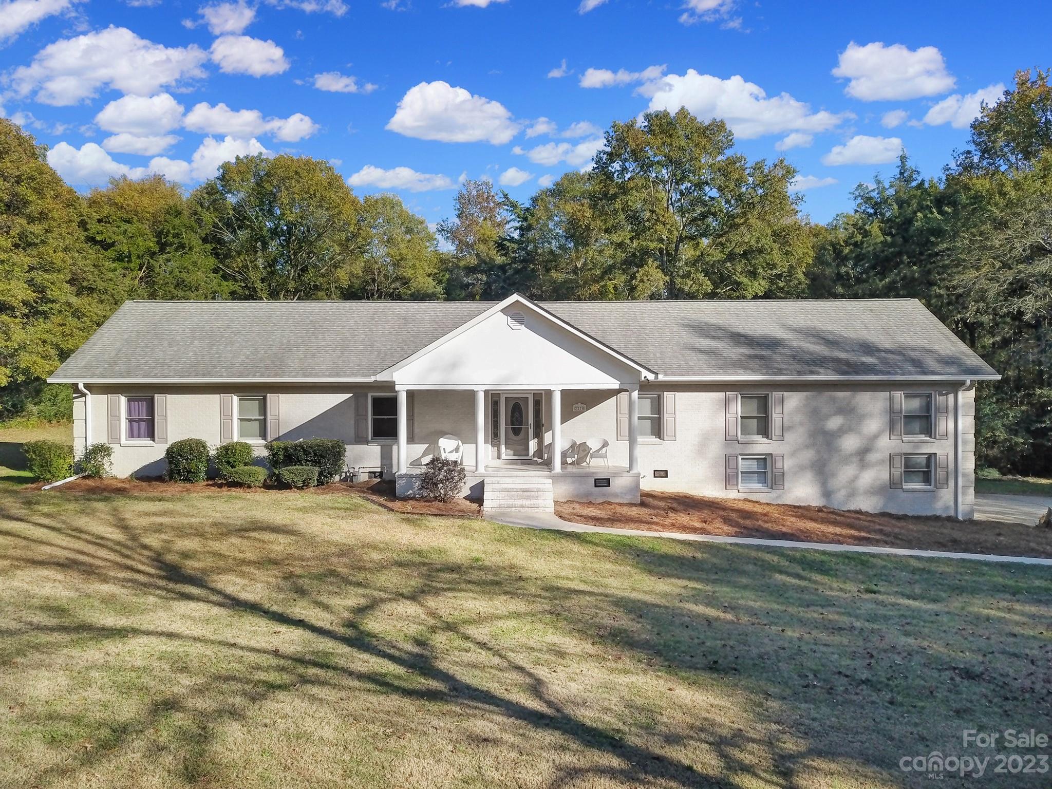 RARE FIND in Fort Mill! Full brick home on 1.6 acres! No HOA dues! Plenty of privacy with the woods in the back! Huge front porch perfect for enjoying your morning coffee! Relax on the expansive back deck while you enjoy your friends and loved ones splashing in the saltwater pool. No shortage of parking with an attached two car garage, plus a detached two car garage/storage building that's heated and cooled. Lots of driveway areas to park additional cars, RV's etc. Kitchen offers stainless steel appliances, white cabinets and the chef in the house will appreciate the gas cook stove. Cathedral ceiling in family room and kitchen makes the home feel extra spacious. Updated primary bath with dual sinks, oversized tile surround shower and walk in closet, plus both full bathrooms feature heated flooring. Home has tankless water heater and tons of storage. Fort Mill Schools!
