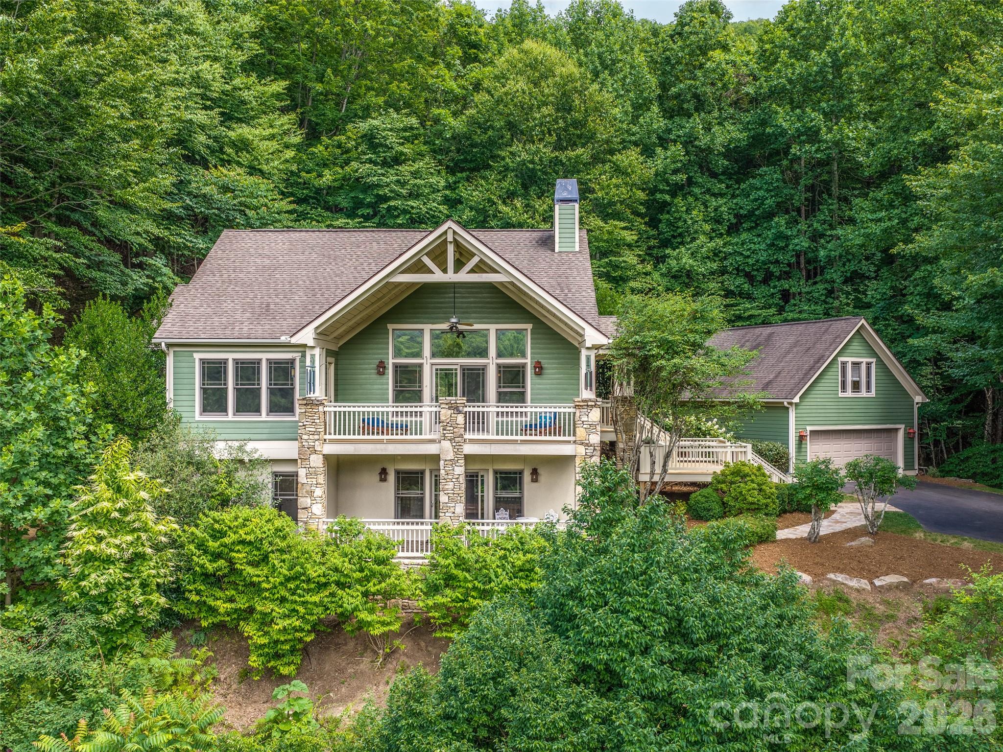 Perched in the gated community of Avery Park, 890 Stoney Stream Lane offers a peaceful lifestyle and mountain views! Designed for comfortable main-level living, the home features an open great room with a soaring beamed vaulted ceiling and a wood-burning fireplace. Step out onto the expansive covered deck for year-round mountain views with the Blue Ridge Parkway in sight! The kitchen and dining area are great for entertaining, and provide ample storage and pantry space. The large primary suite features more mountain views and private access to the covered deck. Downstairs you'll find a space that offers incredible versatility with two additional bedrooms, a full bathroom, a dedicated office space, as well as a theatre system and flex area, currently complete with a pool table. You and your guests can take in more of those stunning mountain views from the lower-level covered flagstone patio. And don't forget the beautifully finished space above the detached two-car garage, perfect for a work-from-home office or creative studio. Life in Avery Park extends far beyond the front door. For a comparably low HOA fee, residents enjoy amenities including a trout pond, swimming pool and cabana, pickleball and tennis courts, a basketball court, and playground. Scenic neighborhood walking trails connect to the Pisgah National Forest, offering immediate access to hiking and outdoor adventure. Plus, AT&T has recently installed fiber optic infrastructure throughout the community for high-speed service. Private, gated, and immersed in nature—yet just minutes from Asheville, the Blue Ridge Parkway, and the North Carolina Arboretum—this home offers the perfect blend of mountain serenity and modern convenience.