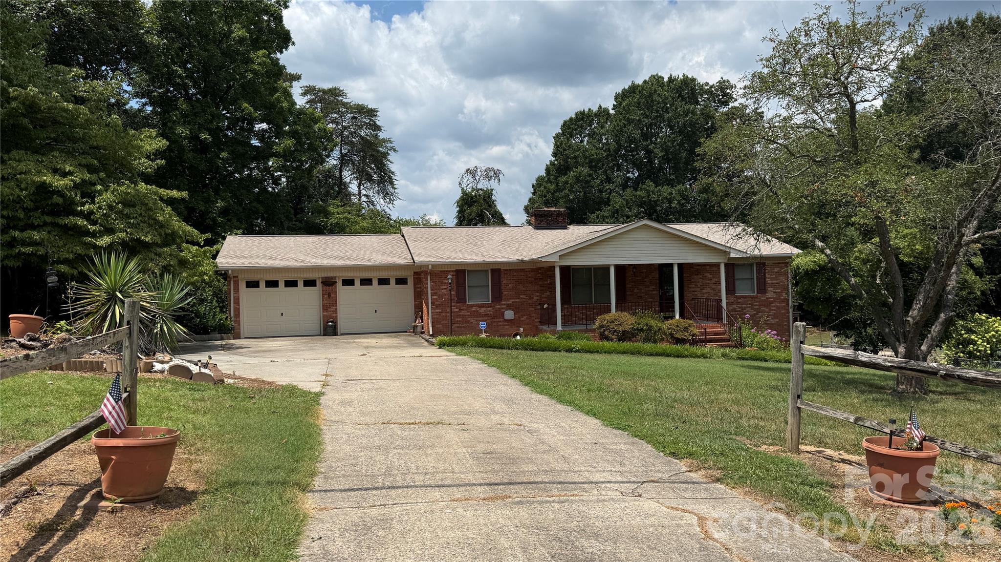 1+ ACRE (2 lots), Privacy and a basement in Oak Wood Neighborhood!  No HOA.    Step inside this well maintained brick home to find new paint, scalloped ceiling designs and updated laminate floor covering.  The kitchen boasts  quality with a plentiful supply  of custom wood cabinetry and granite countertops. A cozy fireplace in the living room and the basement for those who love the crackle of wood burning and an amber light of a warm fire.  The master bedroom is accompanied by the master bathroom and offers entry to the outside deck and stairway.  For those who enjoy a second living area, storage, entertainment, or office area, there is an additional non-permitted heated area in the basement. There is also a second unheated finished room and more unfinished area in the basement,  perfect perfect for expansion.  The exterior features extensive landscaping, an out building, and a large metal carport for tractor or vehicle storage.  This home has so much to offer!