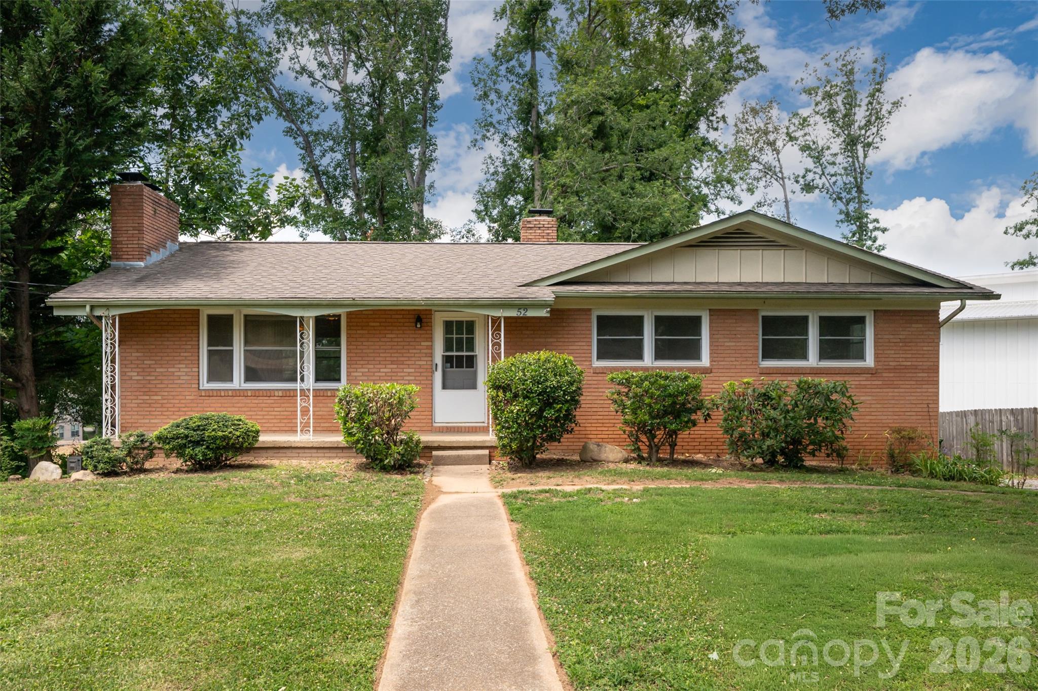 Welcome home to this classic brick ranch in the heart of Royal Pines, where timeless character, flexible living space, and an unbeatable Arden location come together. A welcoming front porch leads into a bright living room filled with natural light, gleaming hardwood floors, and a beautiful wood-burning fireplace that creates an inviting focal point. Just beyond, the dining area flows into a spacious kitchen with abundant cabinetry, generous counter space, and room to gather, making everyday living and entertaining feel effortless. Three bedrooms and two full baths on the main level offer comfortable one-level living with space for family, guests, or a home office. 
The lower level opens even more possibilities with a partially finished walk-out basement featuring its own living area, kitchen, bedroom, full bath, and private entrance. Whether you're looking for a guest suite, multigenerational living, or additional flex space, this layout offers exceptional versatility. Outside, the level yard provides room to garden, play, or simply relax beneath the mature trees, while the attached garage and additional parking add everyday convenience. Located just minutes from South Asheville's shopping and dining, Asheville Regional Airport, Biltmore Park, the Blue Ridge Parkway, and downtown Asheville, this home combines the warmth of an established neighborhood with the convenience and lifestyle that make Arden one of Western North Carolina's most sought-after communities.